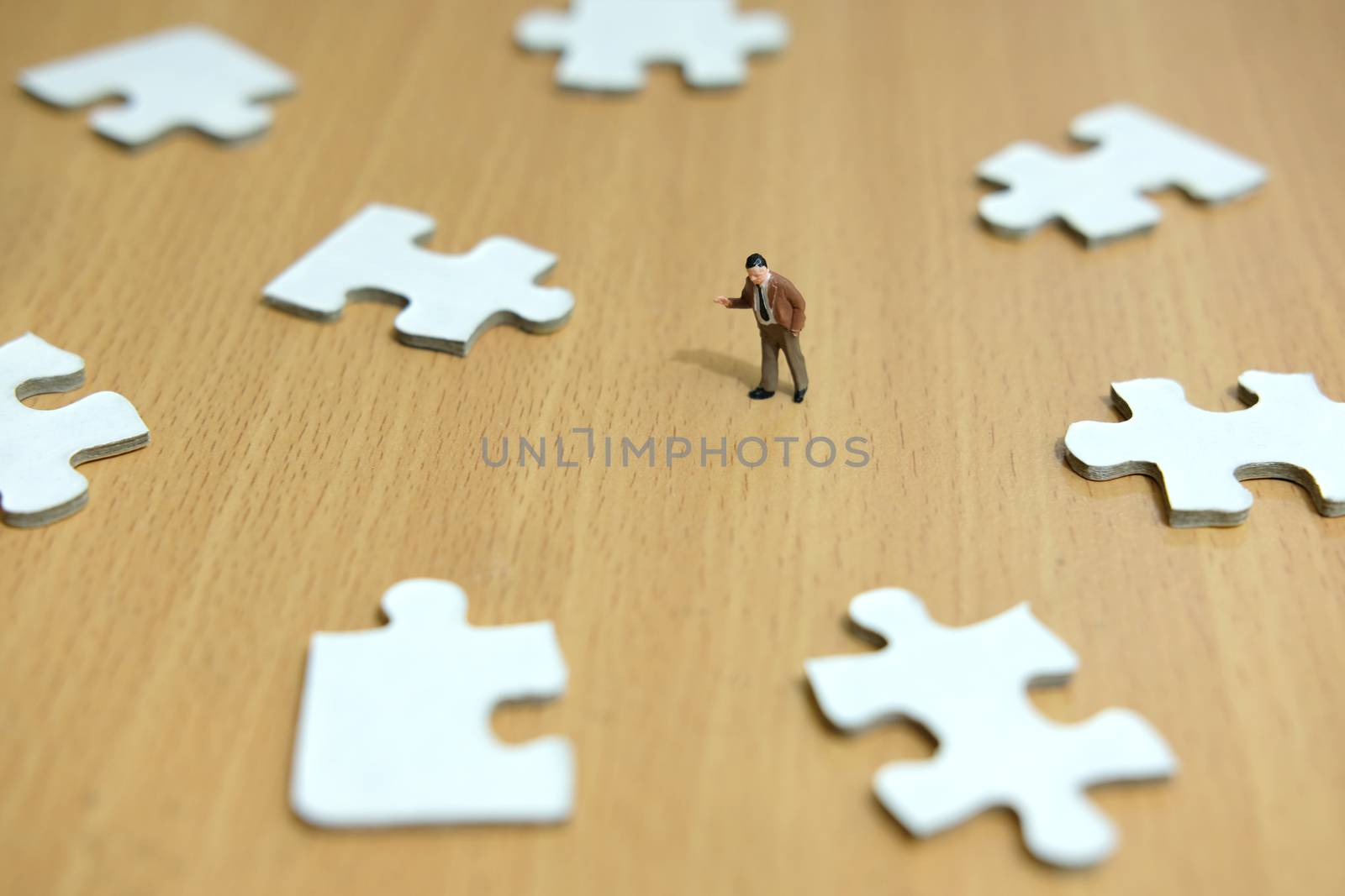 Business strategy conceptual photo - miniature businessman pointing on missing piece puzzle