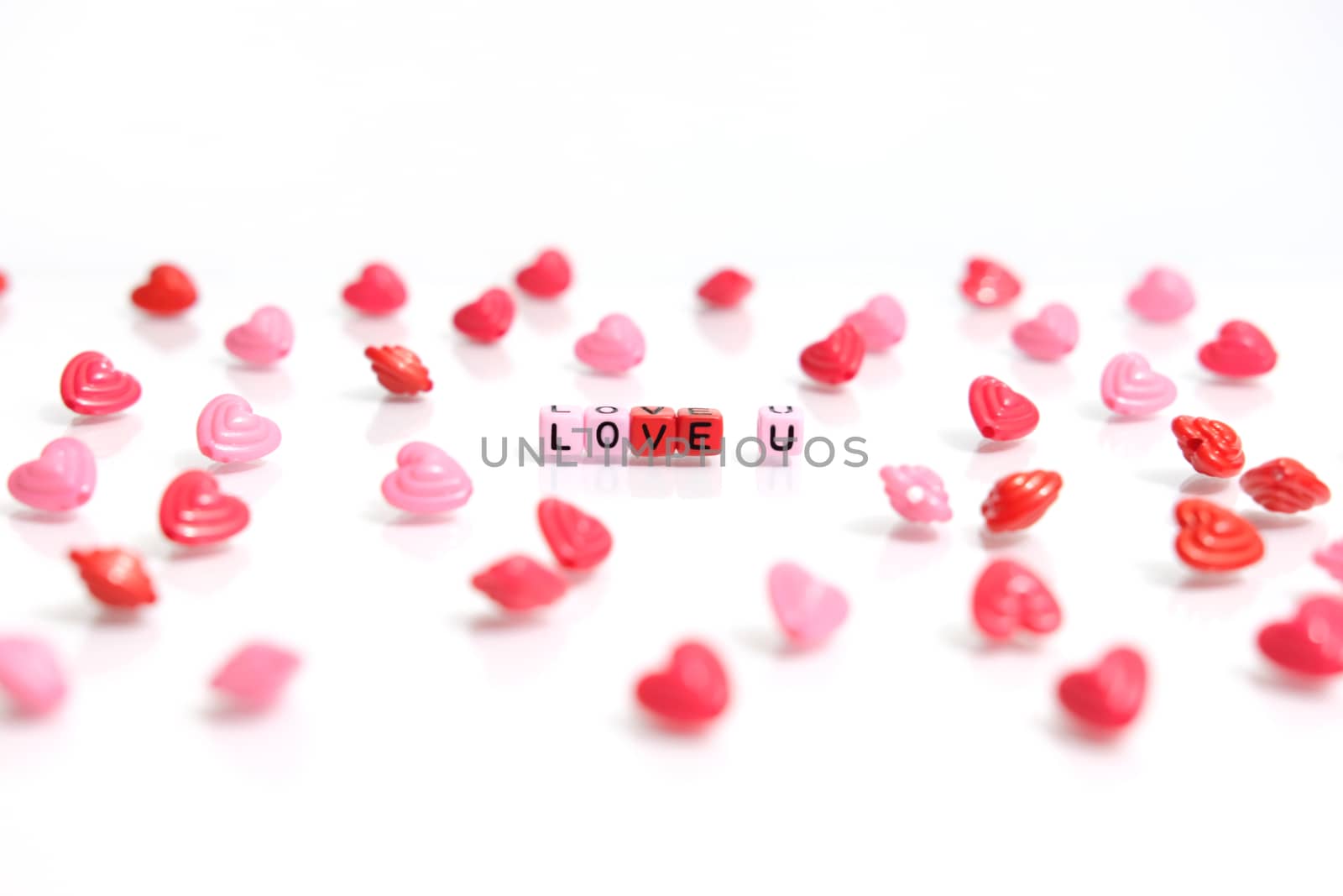 LOVE U word beads in red pink color on white background. Love and romance conceptual object