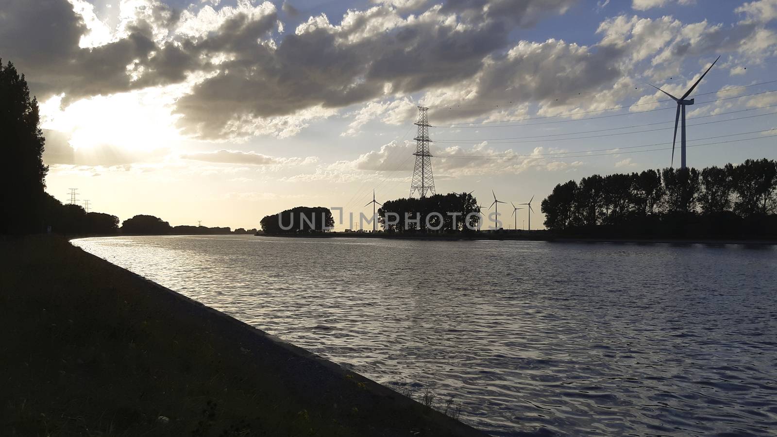 Sunset silhouette on the shore of a canal in industrial area by kb79