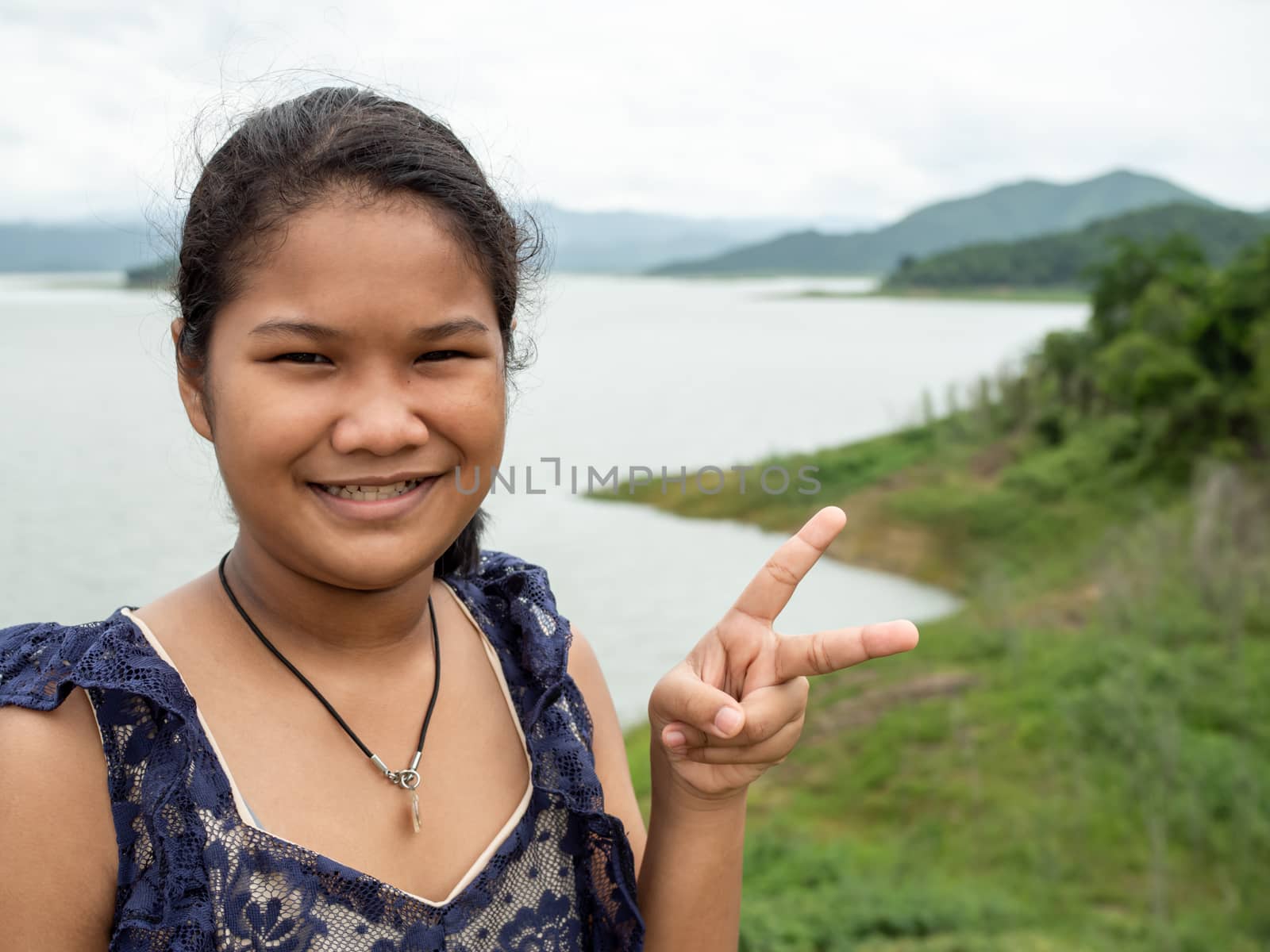 Asian woman Stand on the reservoir background at tourist places in thailand