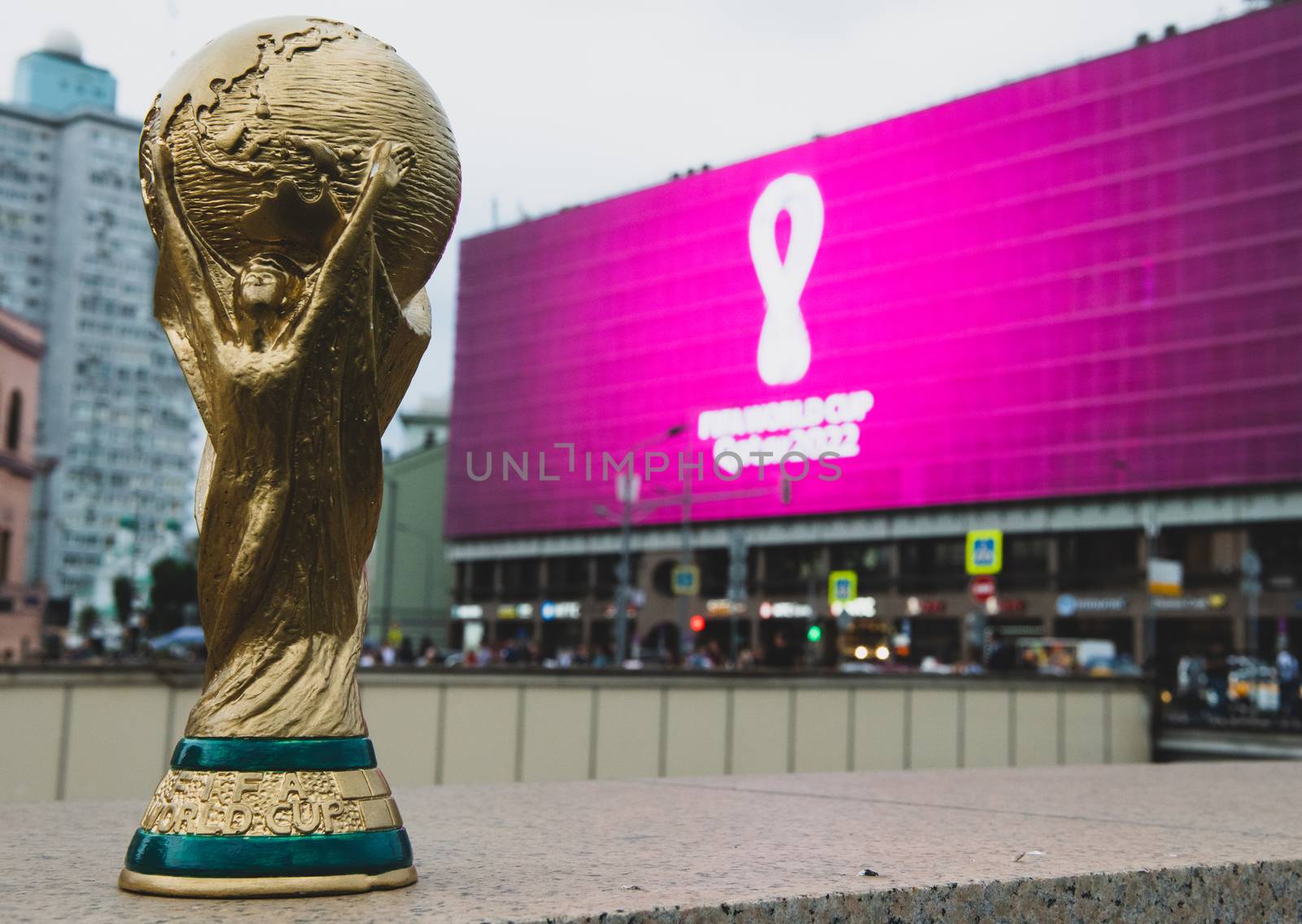 4 September 2019, Moscow, Russia. Copy of world cup trophy on background logo of the FIFA world Cup 2022, which will be held in Qatar, on a giant screen in the city center.