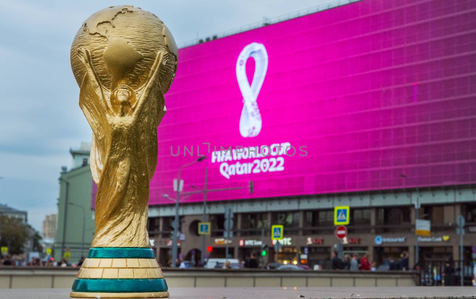 4 September 2019, Moscow, Russia. Copy of world cup trophy on background logo of the FIFA world Cup 2022, which will be held in Qatar, on a giant screen in the city center.