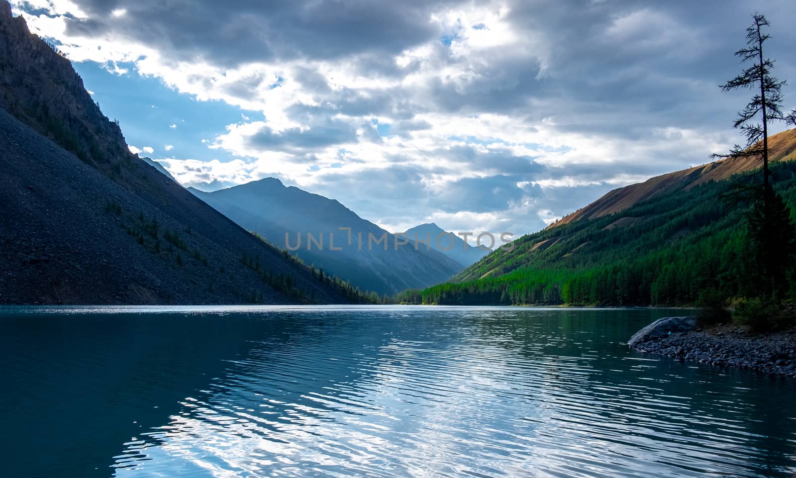 Clouds are reflected in the water of the Shavlinskoye lake in the Altai Republic.