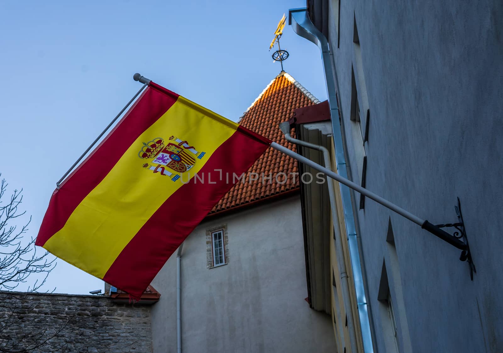 Spanish flag on building against blue sky on bright Sunny day