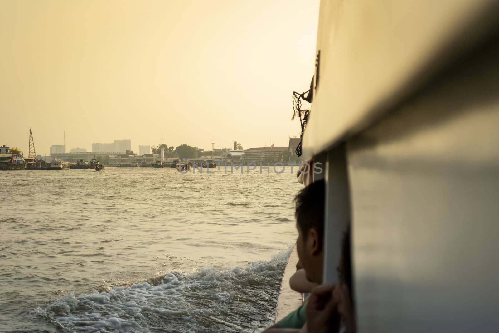 people enjoying a cruise with view on the Chao Phrya river in Bangkok, Thailand during sunset by kb79