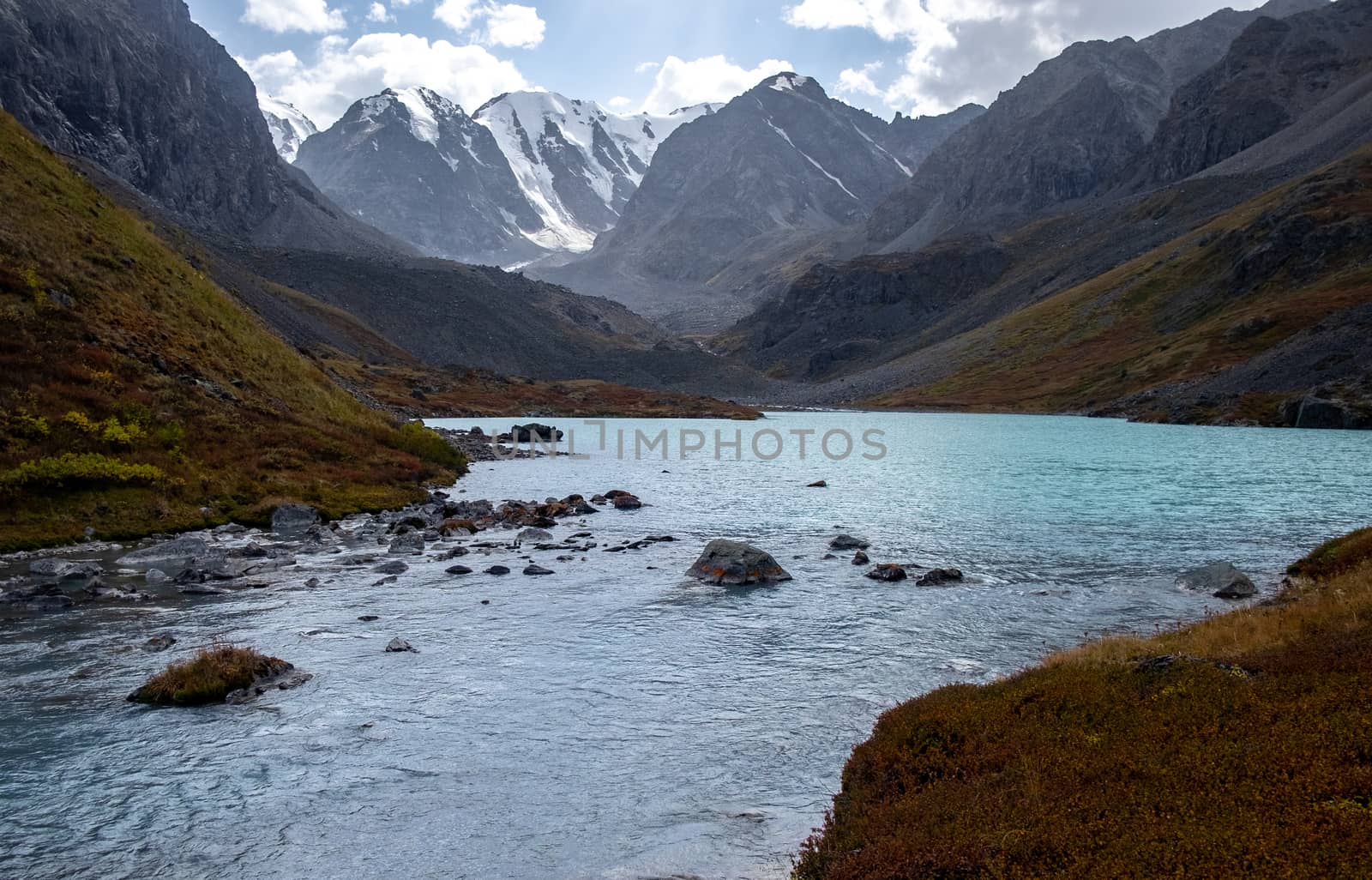 Mountain lake on the background of snow-capped peaks in the Altai Republic.