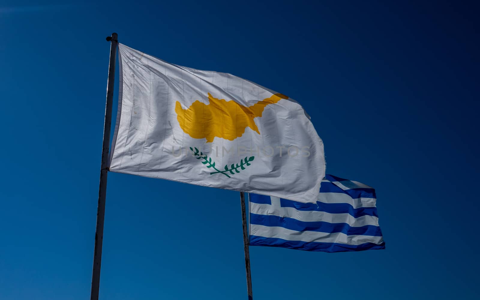 Flags of the Republic of Cyprus and Greece against the blue sky.