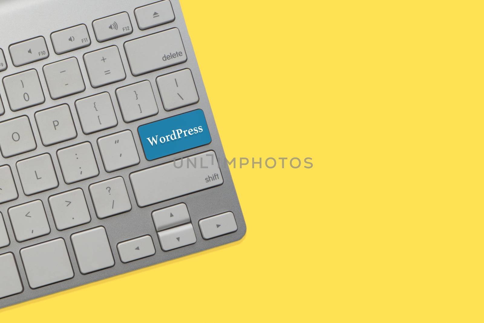 WORDPRESS text on keyboard over yellow background. Business and technology concept by silverwings