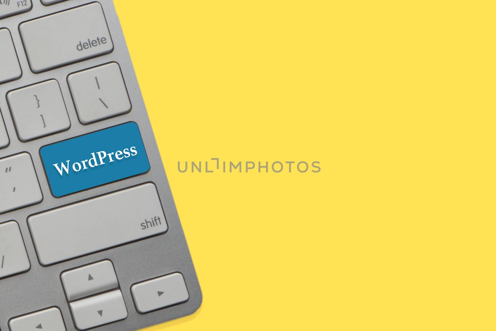 WORDPRESS text on keyboard over yellow background. Business and technology concept by silverwings