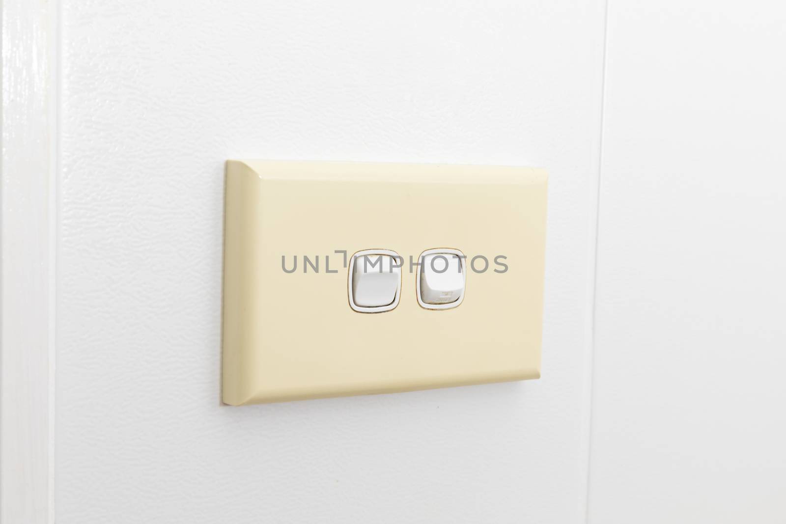 A double light switch on a white tiled wall by WittkePhotos