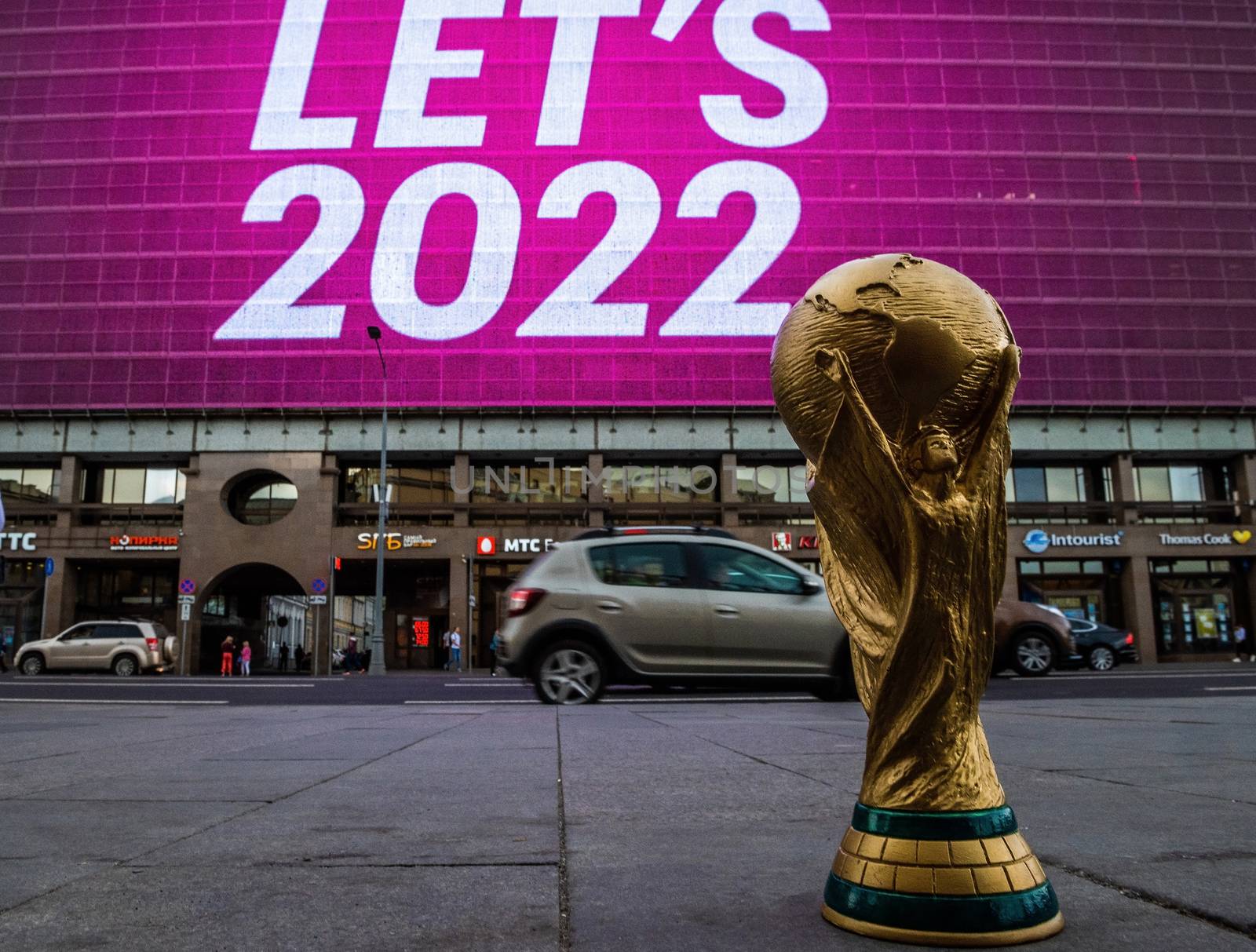 4 September 2019, Moscow, Russia. Copy of world cup trophy on background logo of the FIFA world Cup 2022, which will be held in Qatar, on a giant screen in the city center.