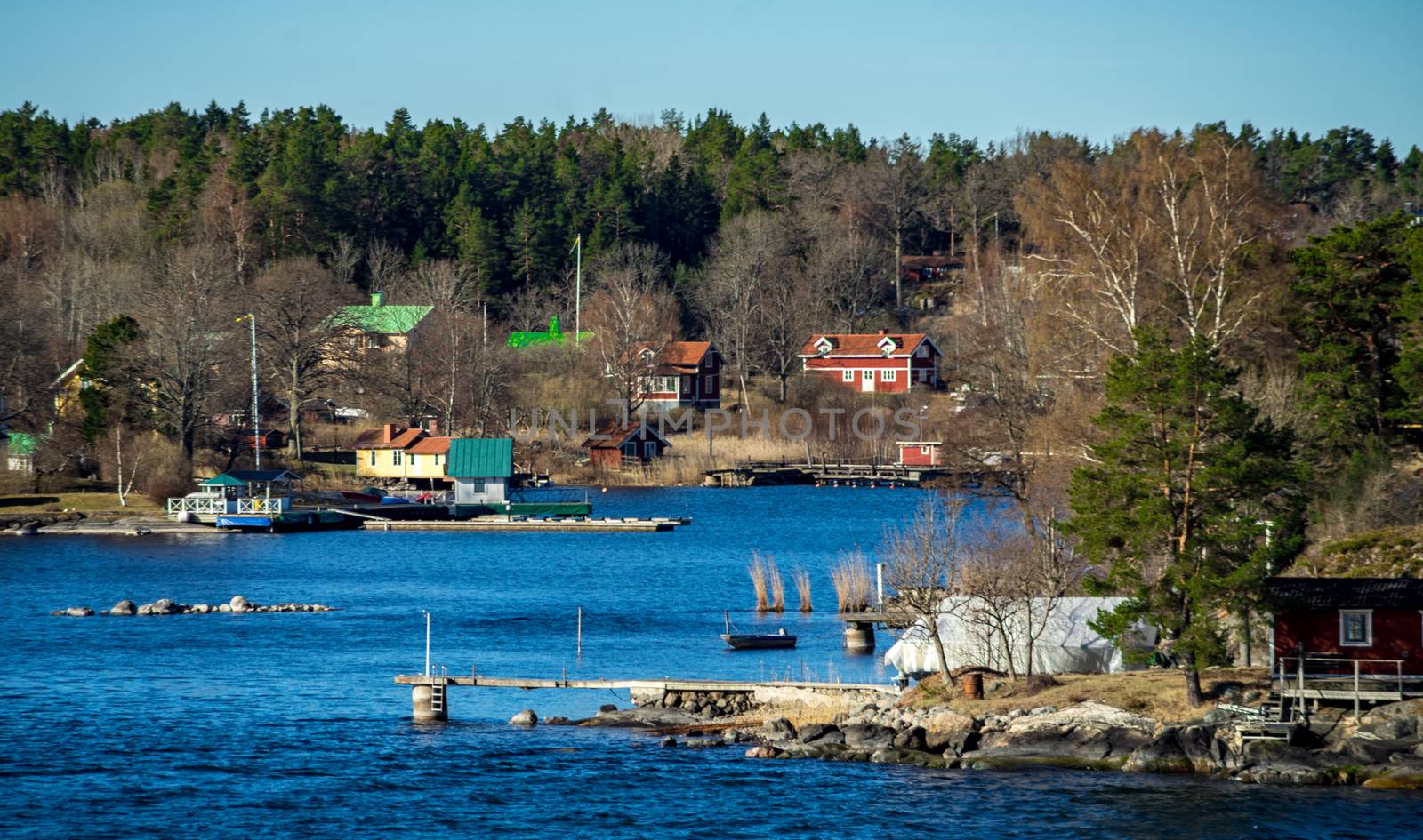Picturesque summer houses painted in traditional falun red on dwellings island of the Stockholm archipelago in the Baltic Sea in the early morning.