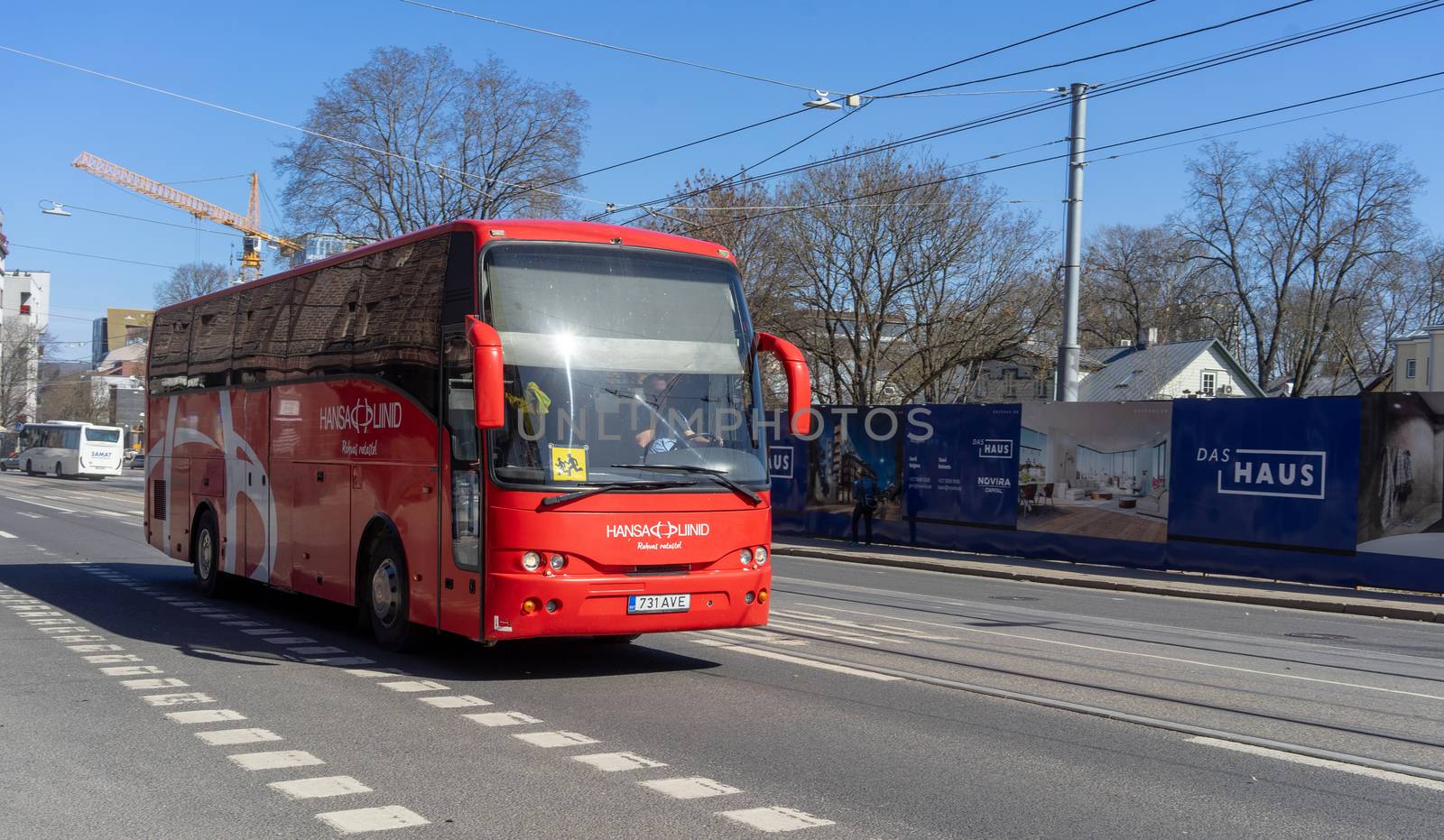 April 20, 2018, Tallinn, Estonia. A red bus with an information sign caution children on a windshield on a street in Tallinn.