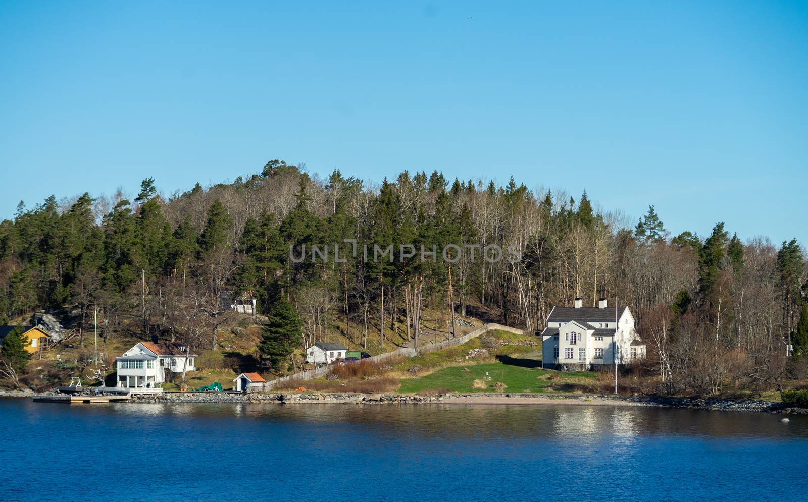 Picturesque summer houses painted in traditional falun red on dwellings island of the Stockholm archipelago in the Baltic Sea in the early morning.