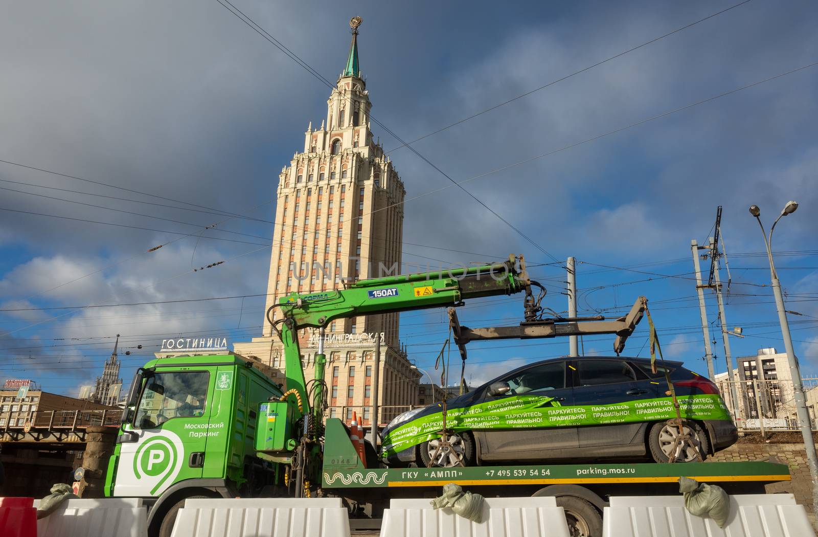 April 1, 2019 Moscow, Russia. A tow truck takes a car to a Parking lot on the background of the building of the Leningradskaya hotel on the square of Three stations in Moscow.
