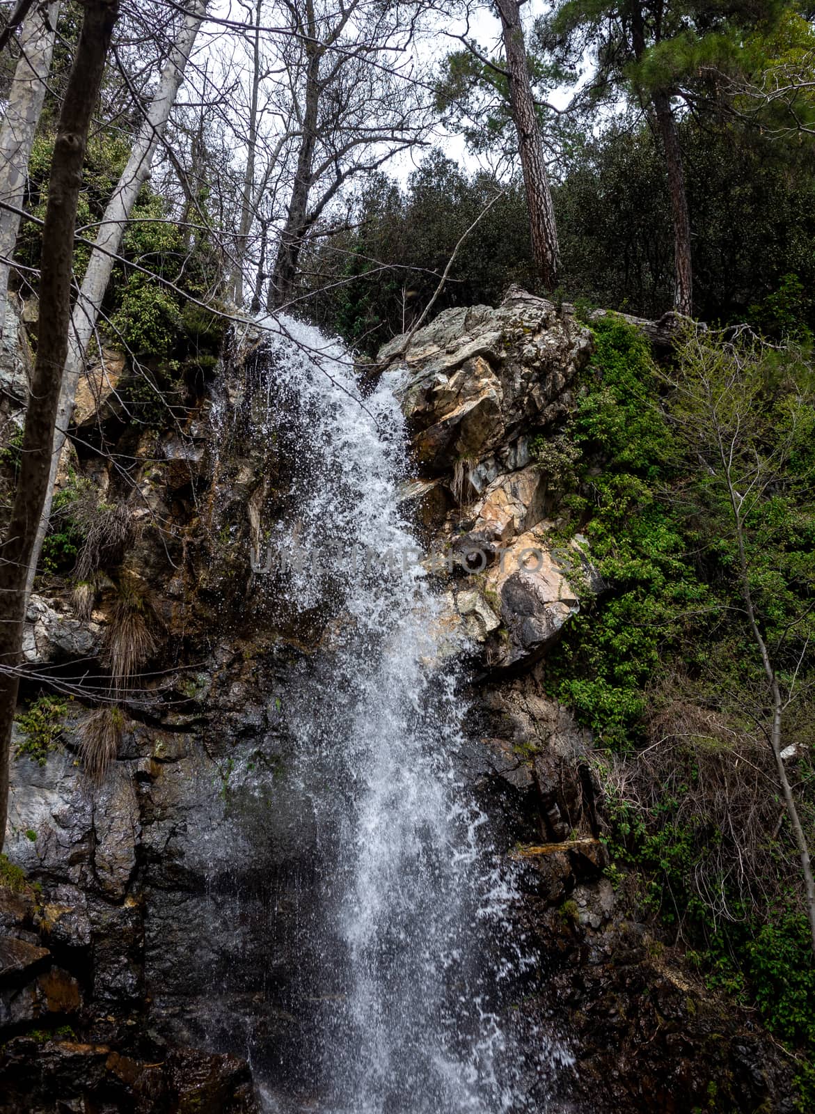 Waterfall on a mountain river in the hot summer in the mountains of Central Cyprus.