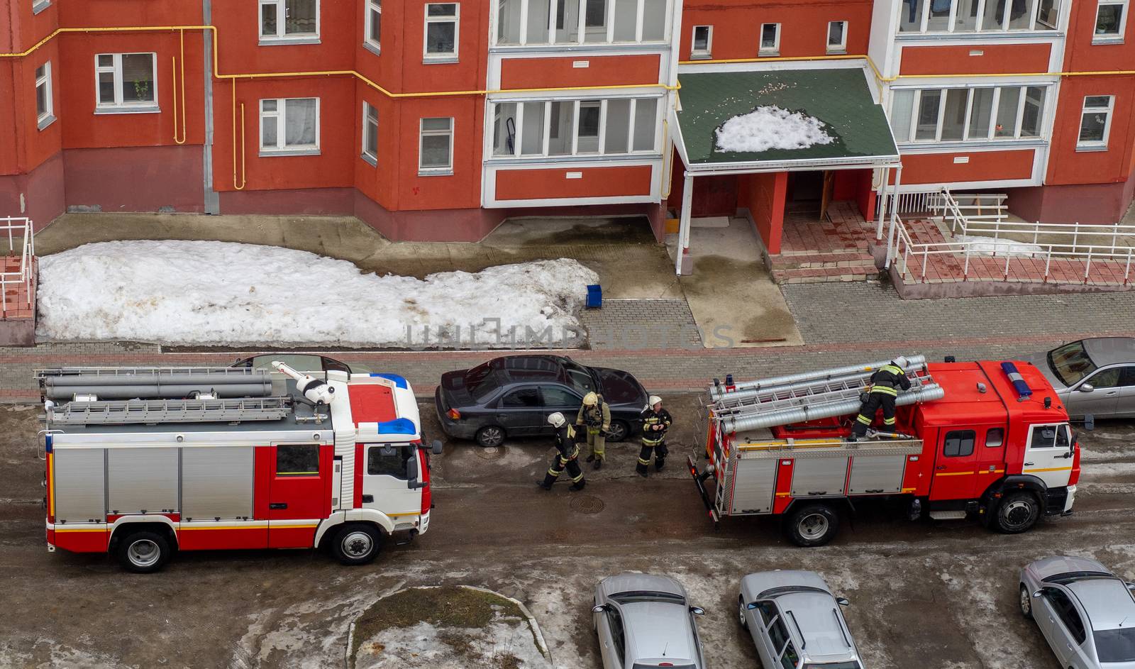 Fire engine in the courtyard of a multi-storey residential building in winter.