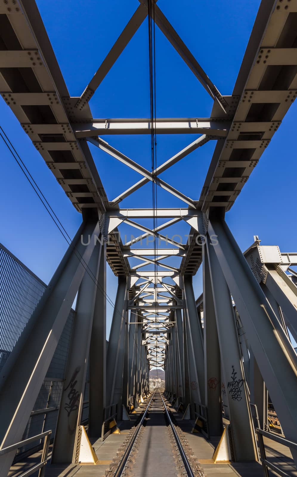 Modern railway steel bridge over highway