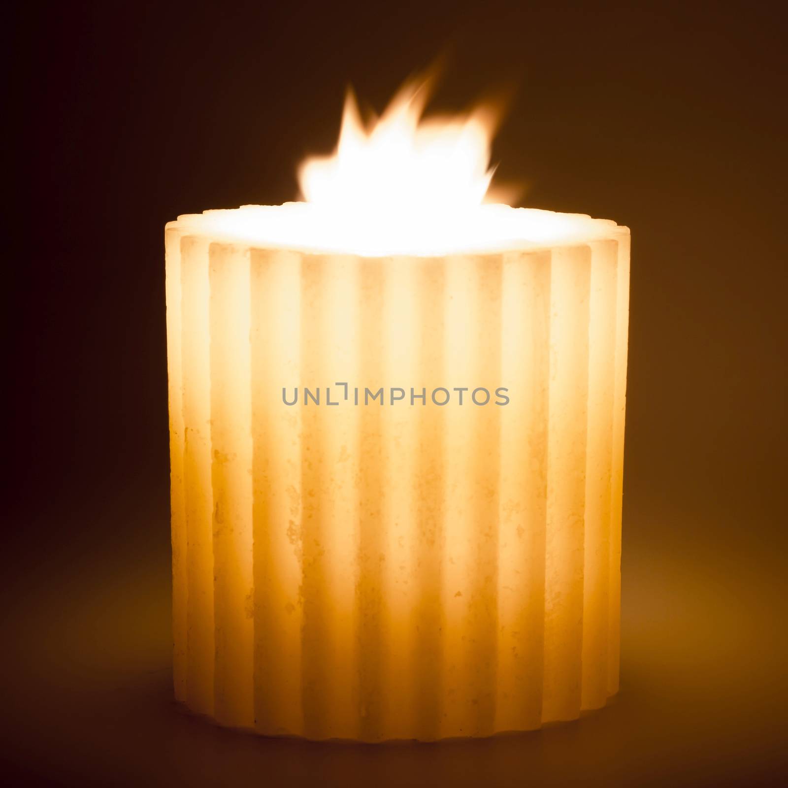 Isolated burning candle on dark background