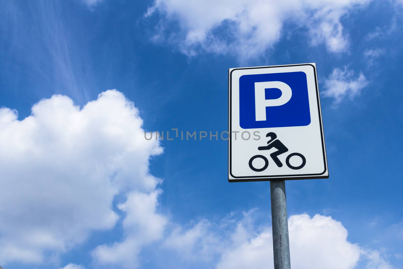 Road sign of parking motorcycle with blue sky in the background
