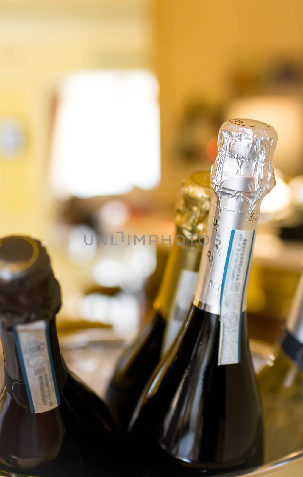 Bottles of sparkling wine in an ice bucket. Selective focus. Defocused blurry background.