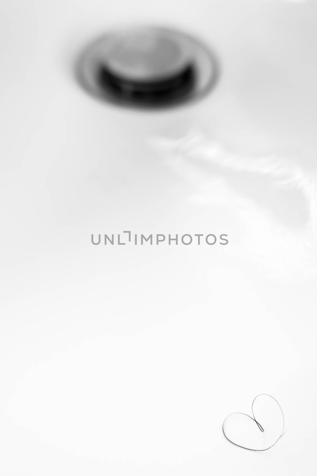 Heart-shaped pubic hair in a sink out of focus. Ideal for concepts, events and backgrounds.