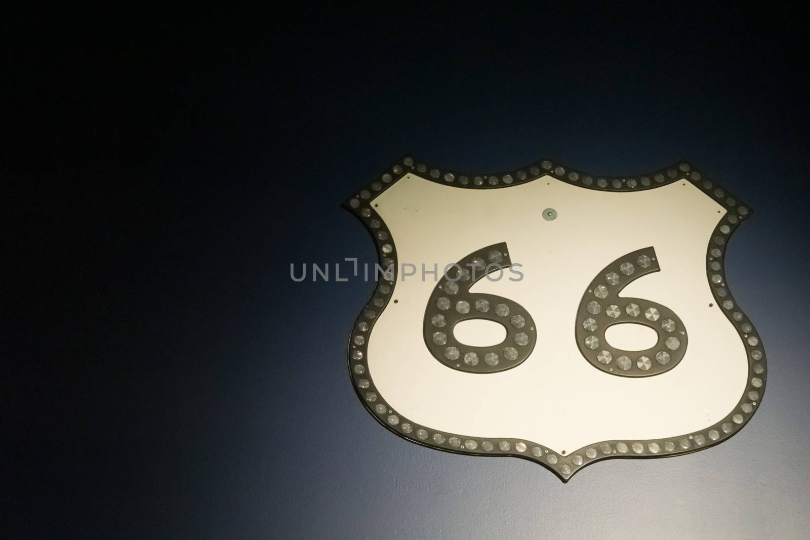 Vintage Route 66 sheild sign on dark background.