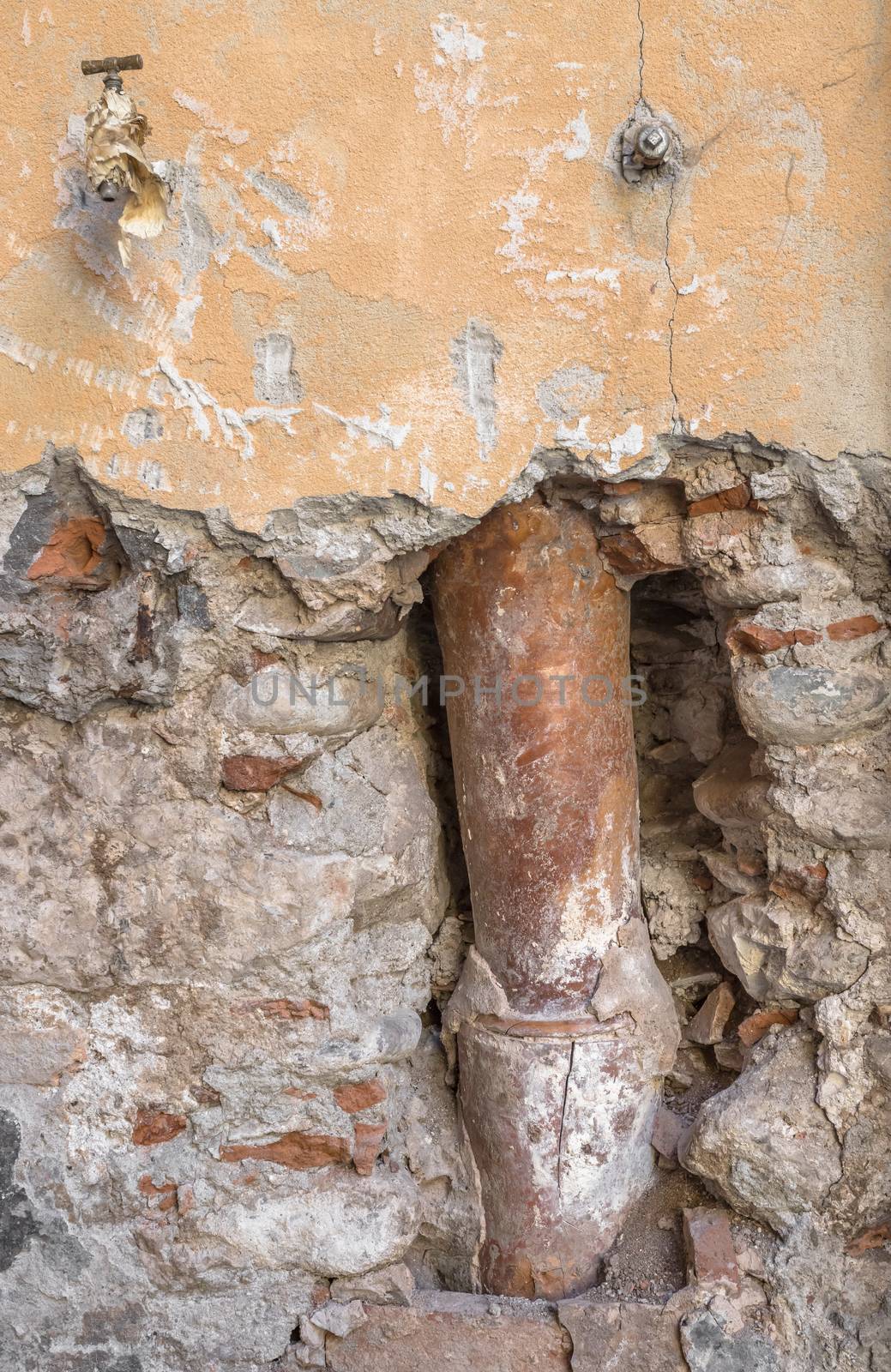 Old gutter inside the broken wall by germanopoli