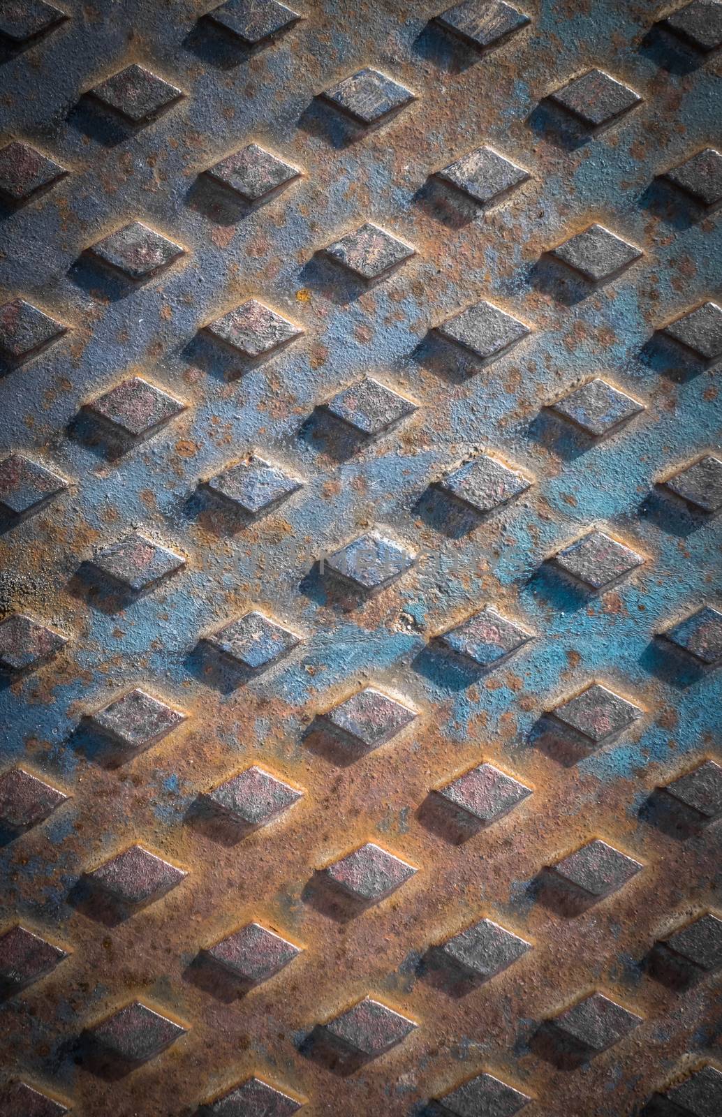 Old rusty drain cover background with diamond pattern.