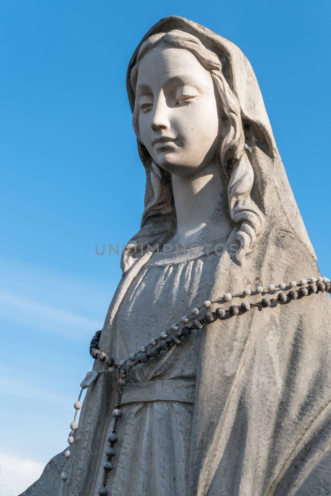 Virgin Mary Statue. On background a blue sky. Ideal for concepts and festivity.