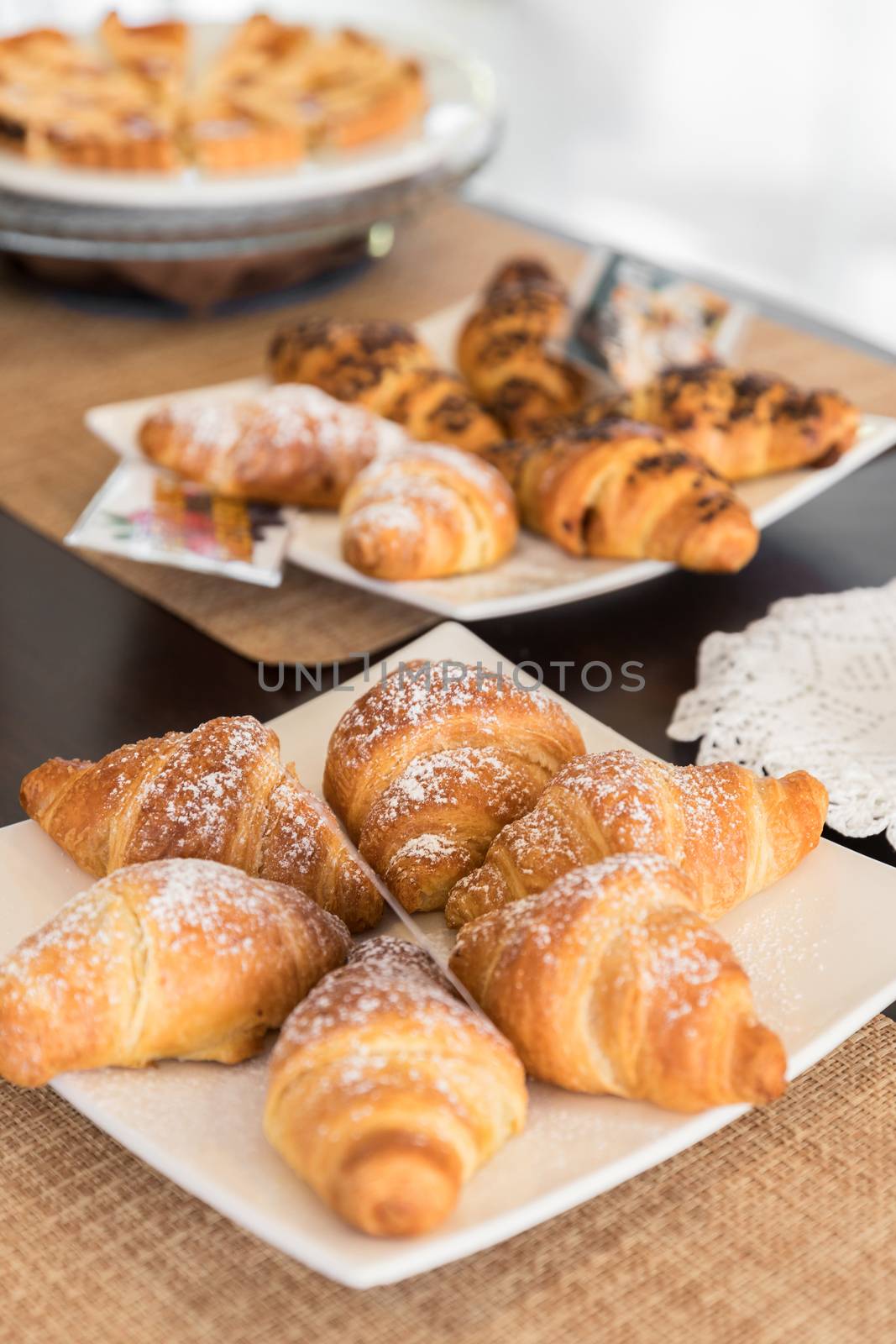 Selection self service continental breakfast buffet display, catering or brunch table food buffet filled with delicious croissants and homemade cakes in a hotel or restaurant setting.