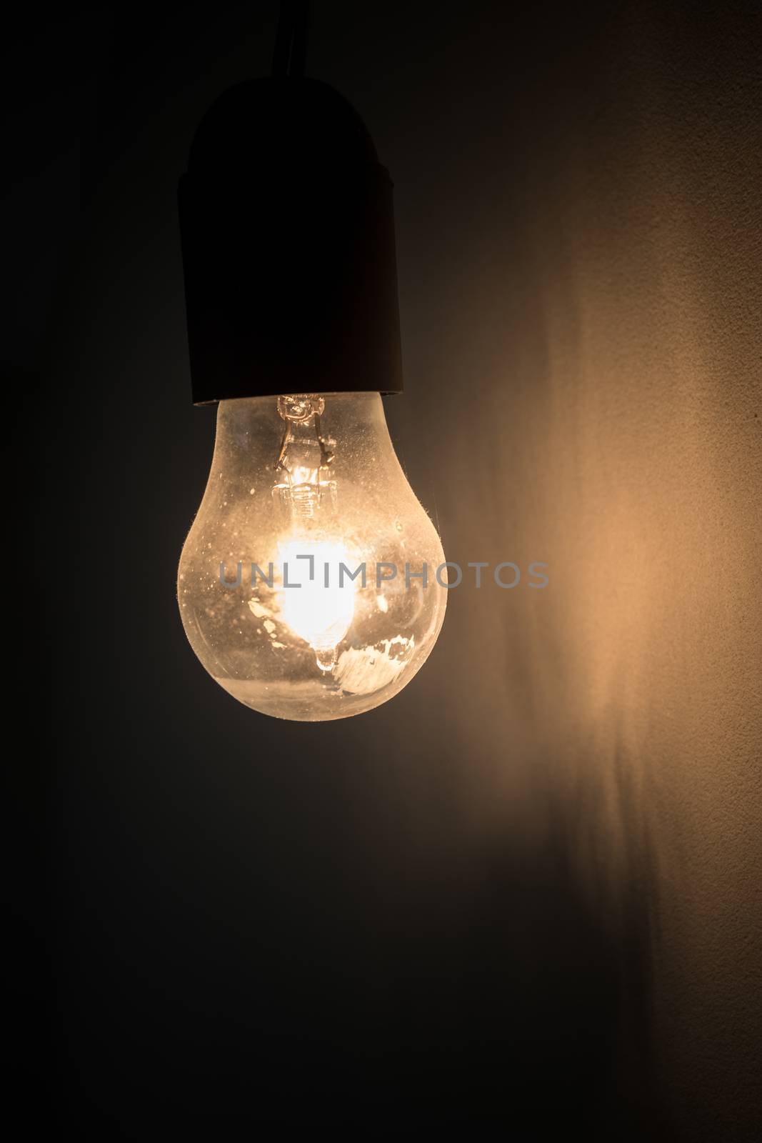 Old vintage light bulb glowing in the dark. Ideal for concepts.