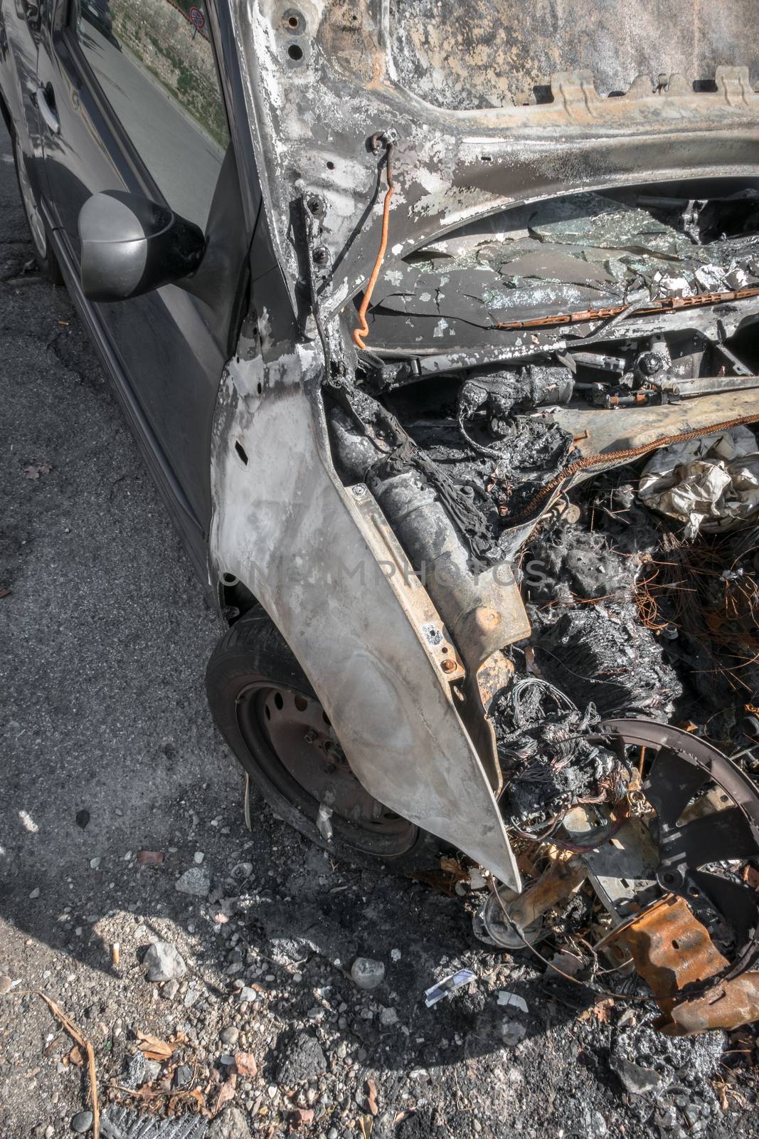 Burnt car on a city street. View from above.