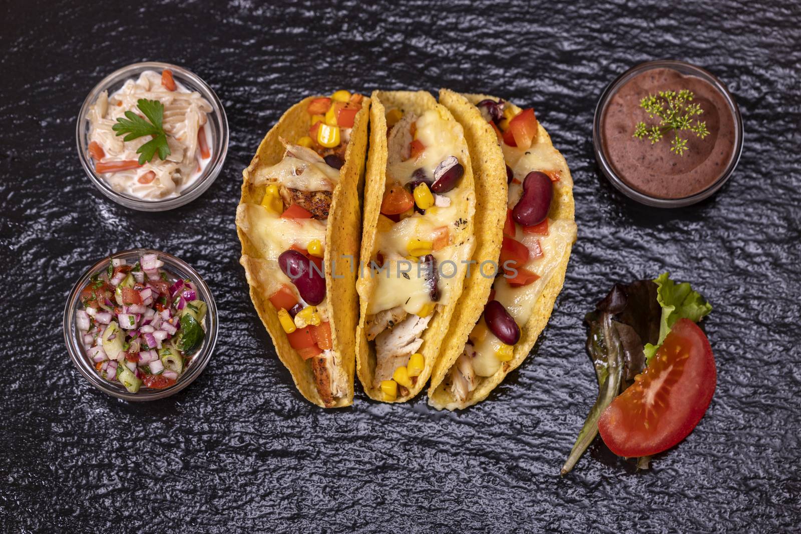 three mexican tacos on slate