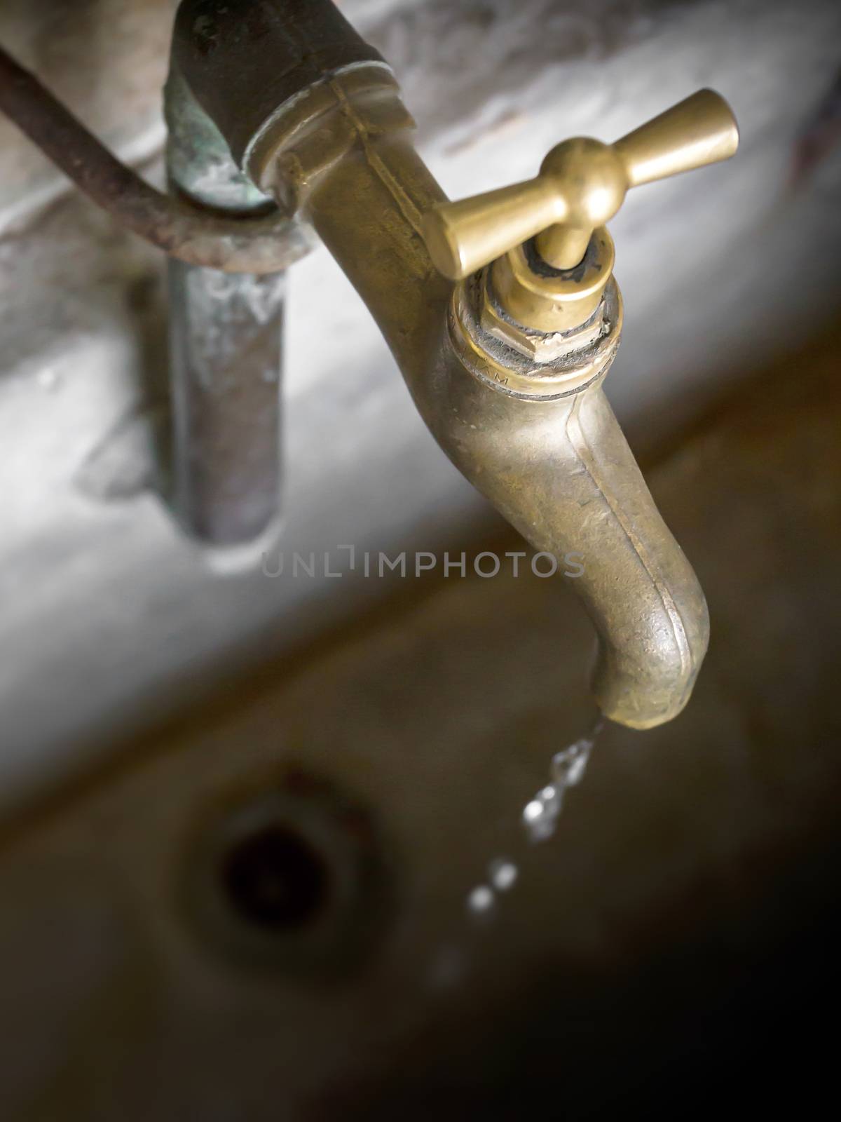 Water shortage concept. Old leaky dripping faucet.