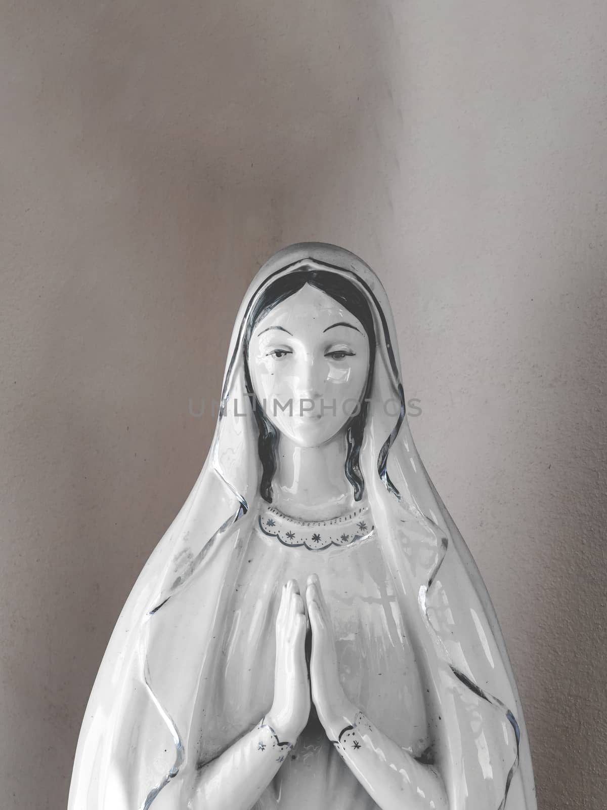 Virgin Mary porcelain statue in a vintage background