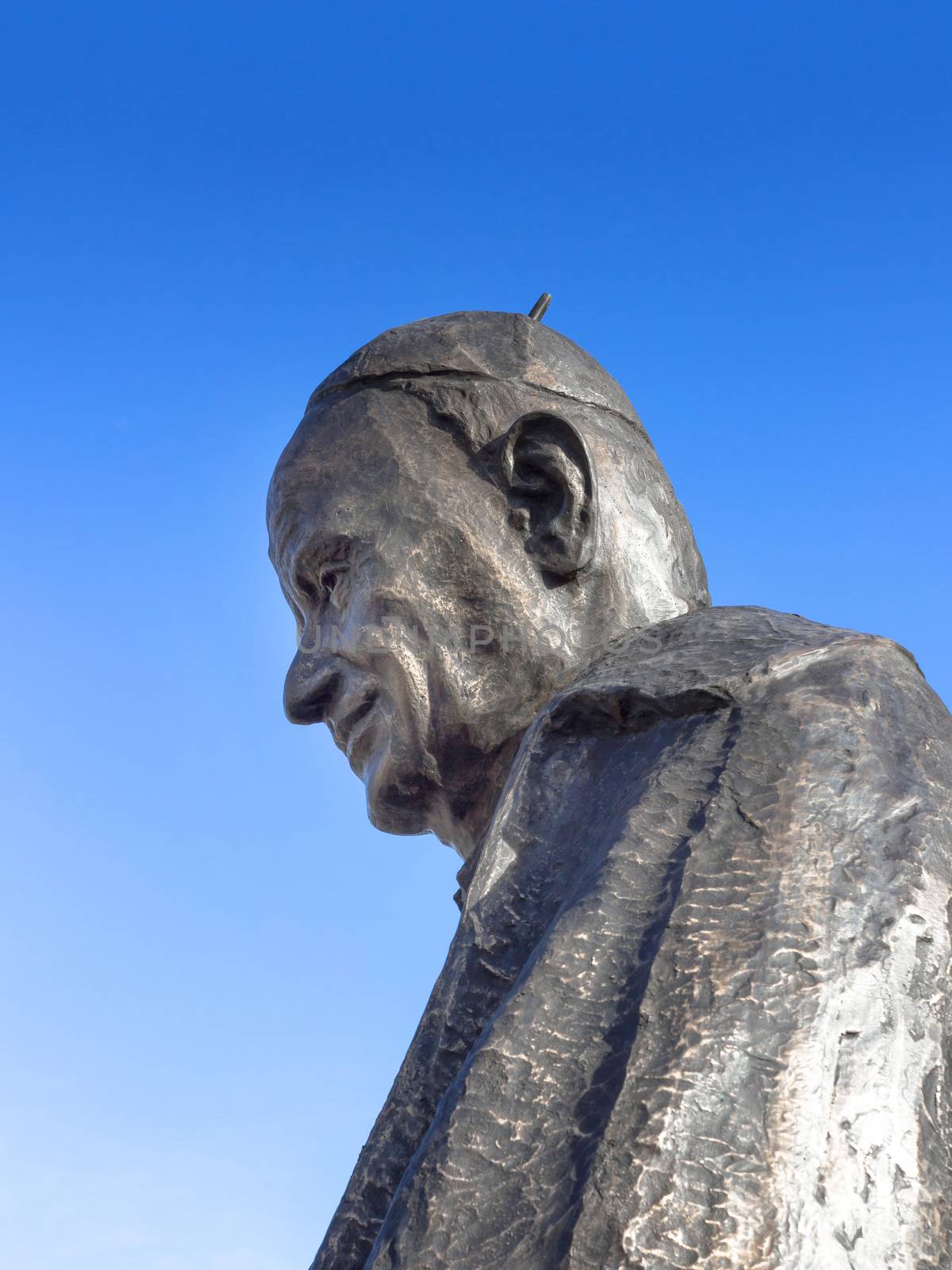 Statue of Pope John XIII against blue sky. Copy space.