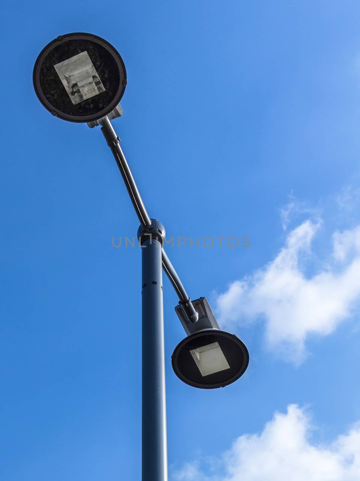 Modern street light lamp on a blue sky background. Copy space.