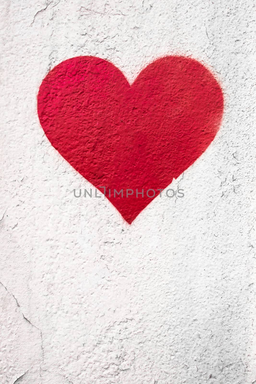 Red love heart hand drawn on grungy wall. Textured background trendy street style. Copy space.