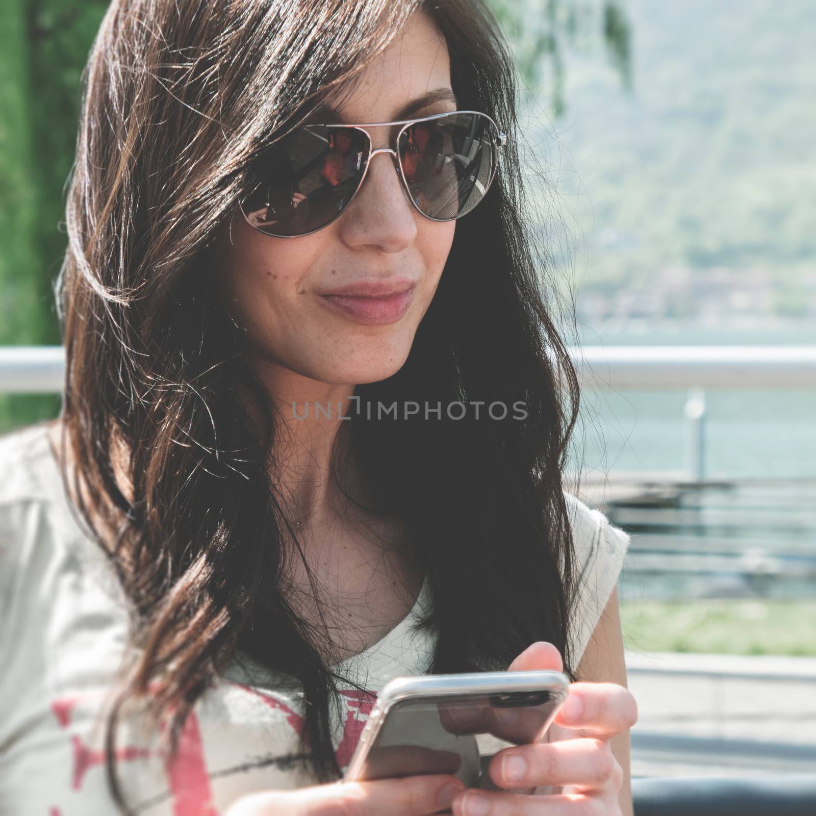 Young woman using smartphone. Urban women lifestyle technology. Vintage style. Soft focus.