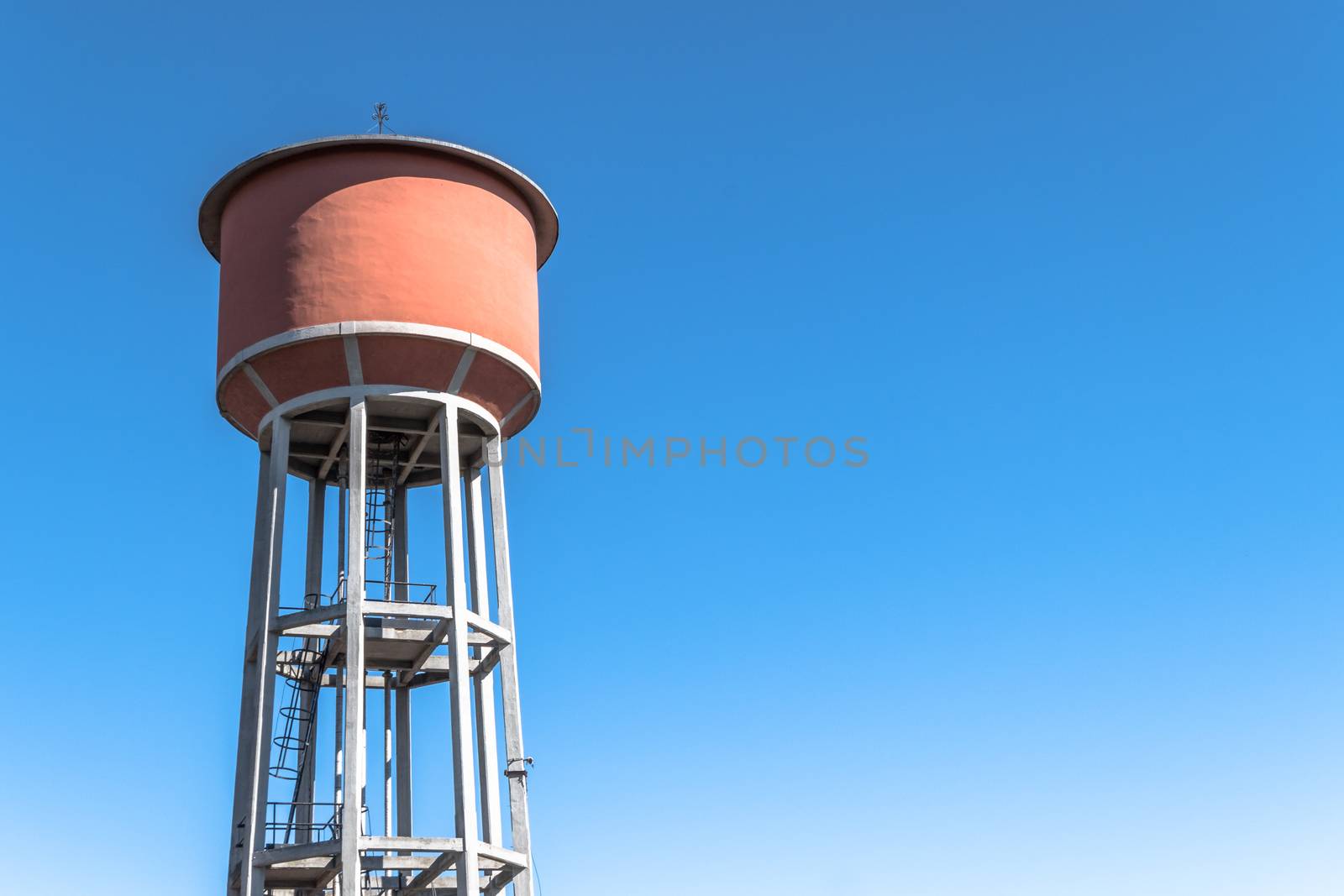 Water tower tank, providing a rural area with fresh water, from high above, under an expansive blue sky for copy space.