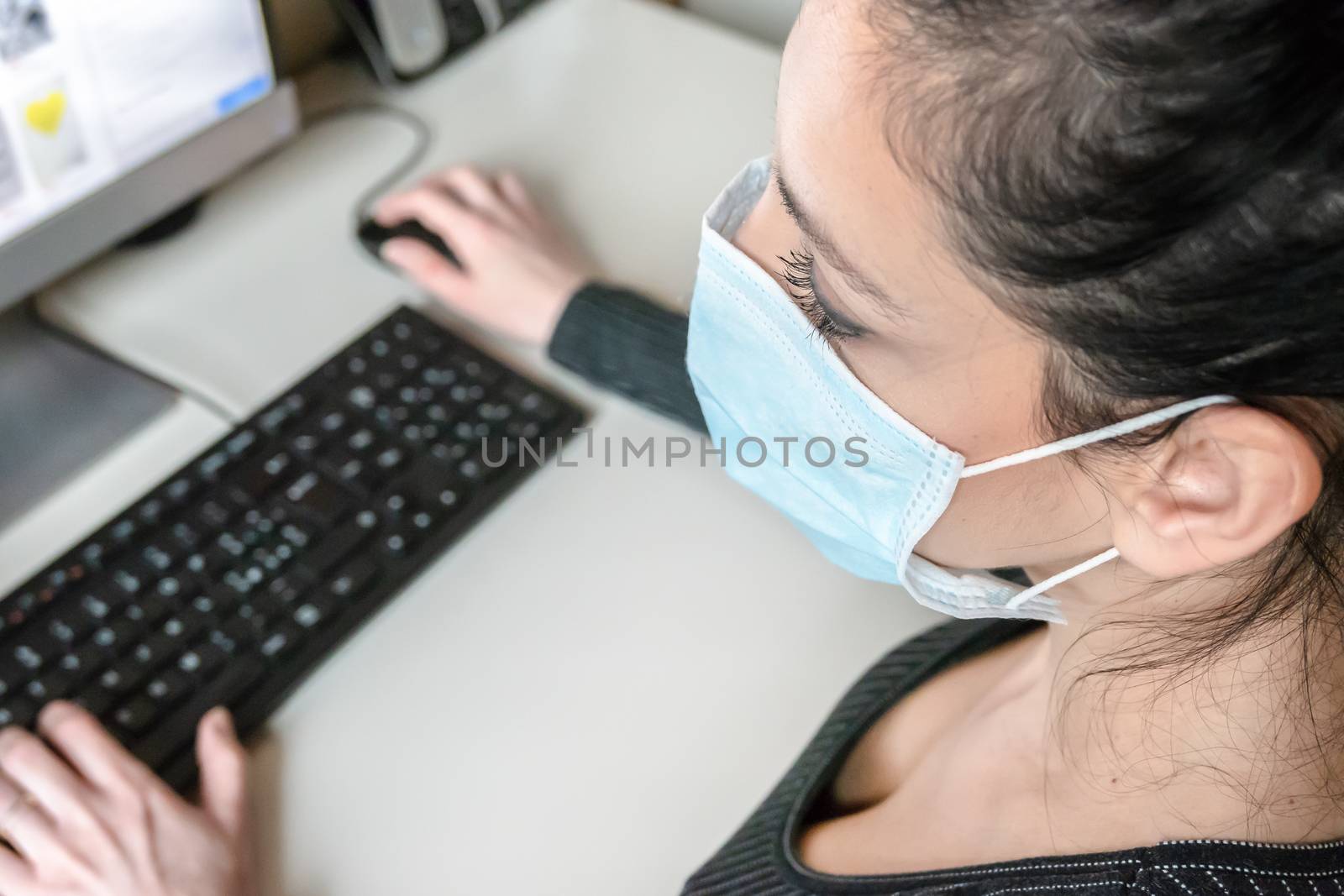 Young business woman working from home wearing protective mask. Coronavirus. Business woman in quarantine for coronavirus wearing protective mask. Working from home.