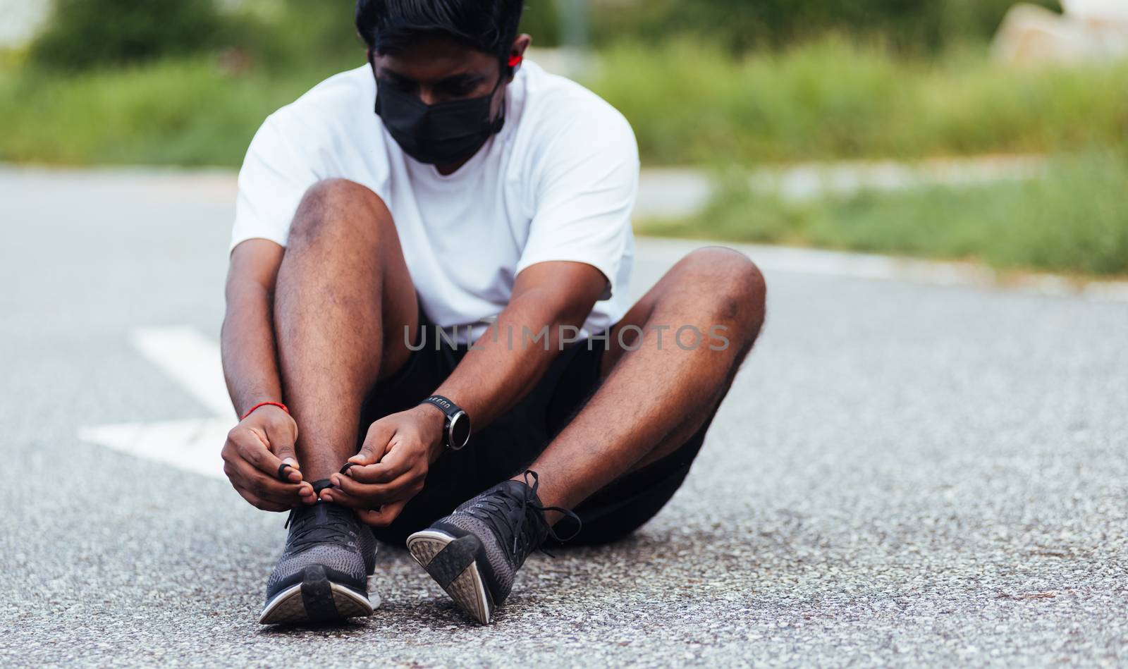 Close up Asian sport runner black man wear watch sitting he trying shoelace running shoes getting ready for jogging and run outdoor street health park with copy space, healthy exercise workout concept