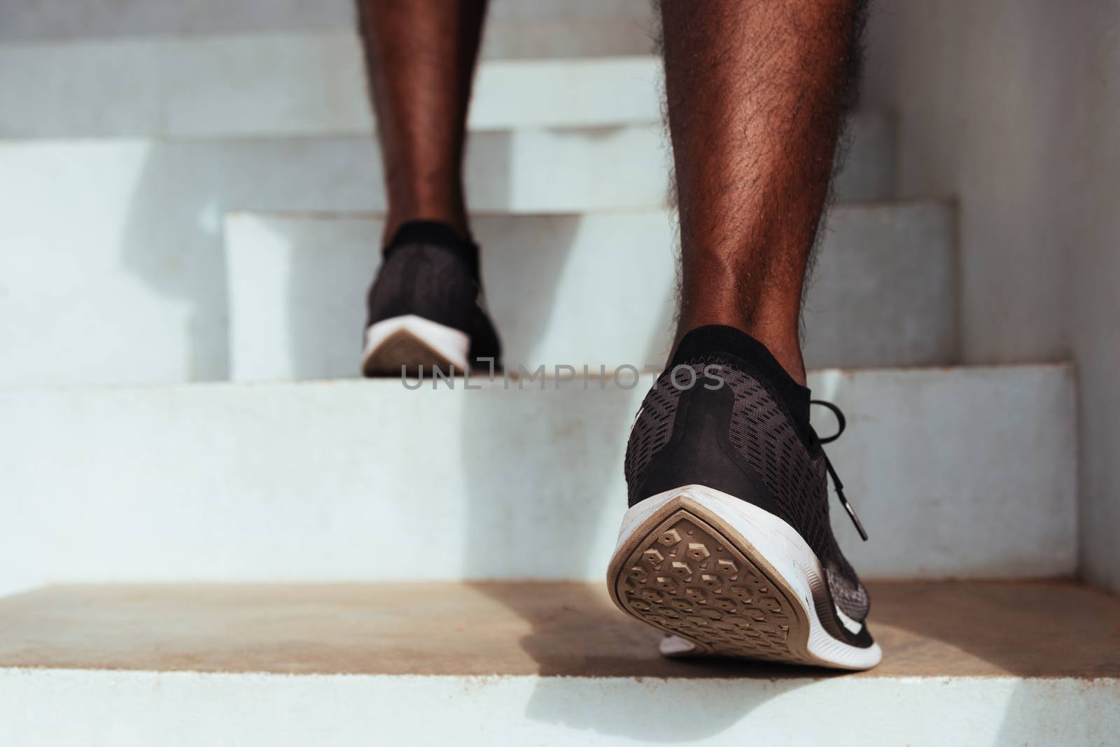 sport runner black man step running up to climbing stairs by Sorapop