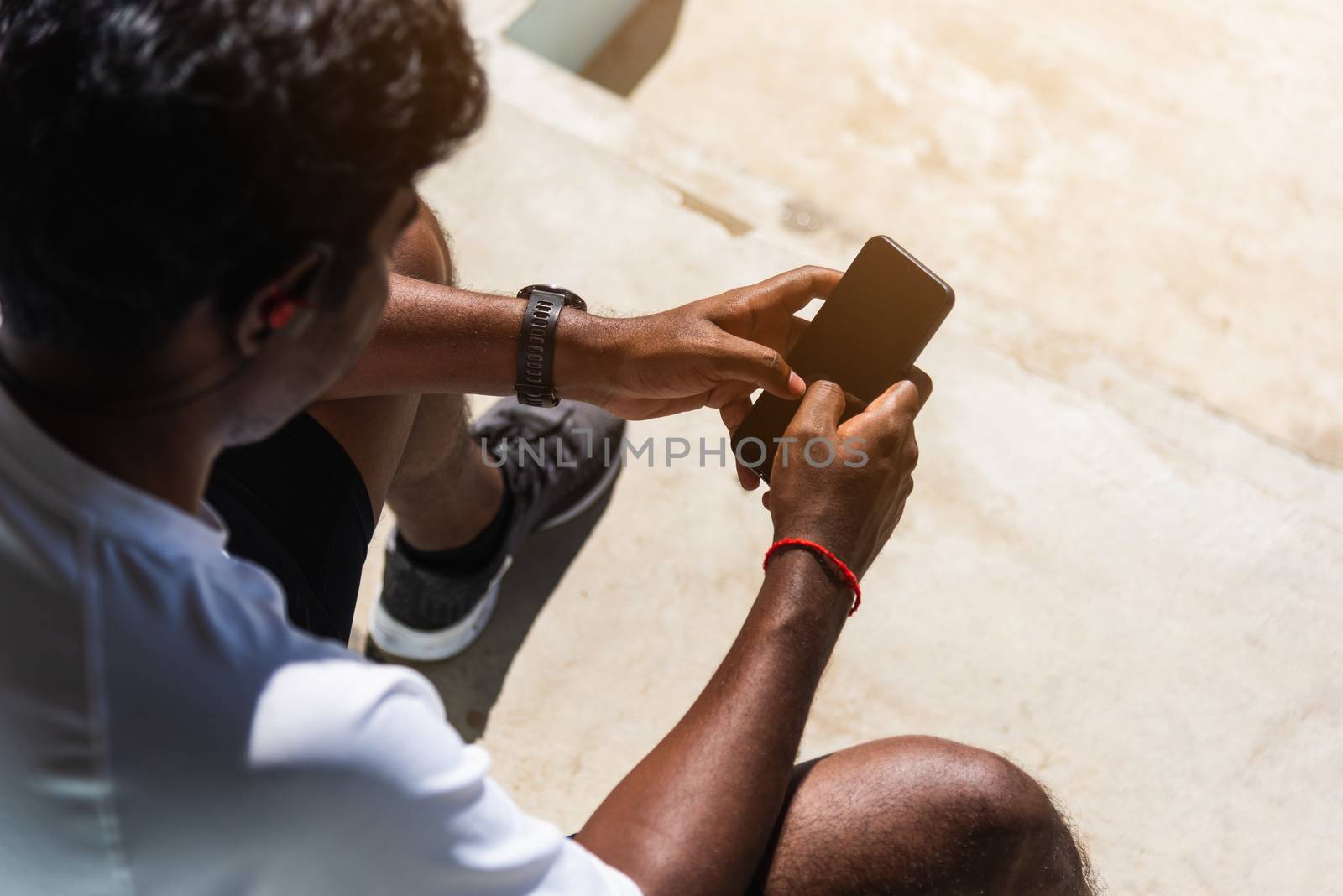 Close up Asian young athlete sport runner black man wear modern time smart watch and sync to a smartphone check running result after training run at the outdoor, healthy exercise workout technology