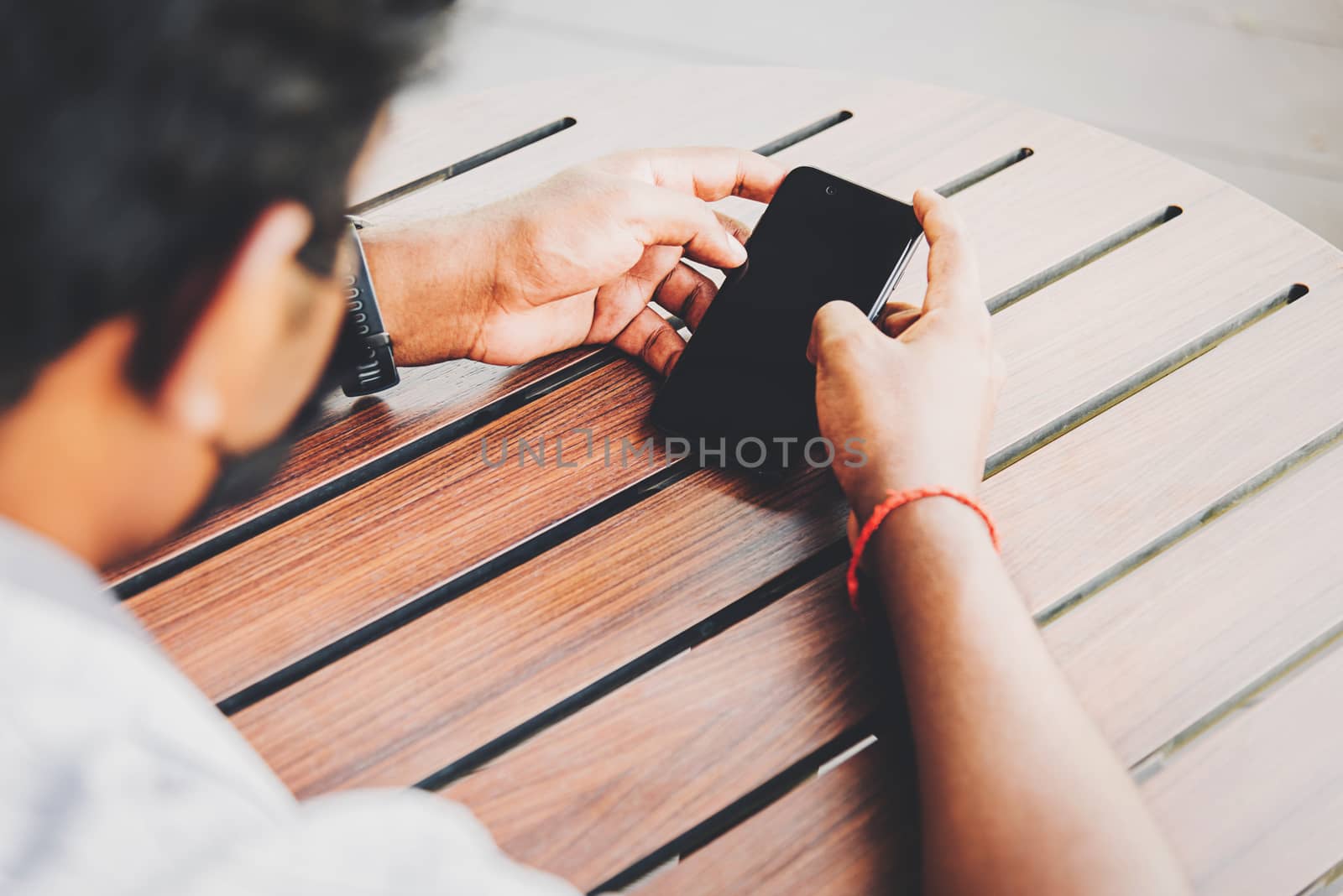 black businessman person holding a modern digital smart phone bl by Sorapop
