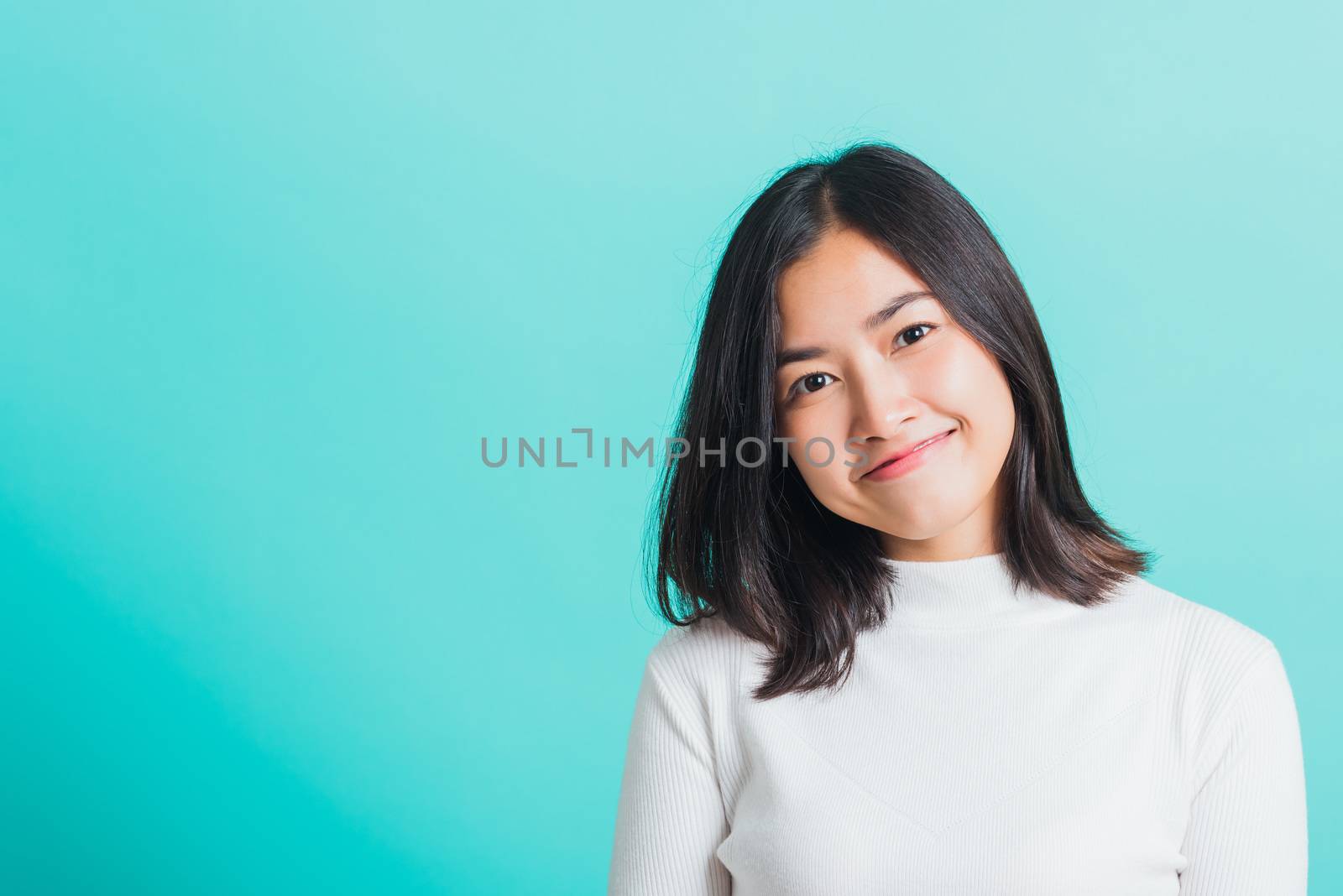 Portrait of Asian teen beautiful young woman Wear a white T-shirt smile clean skin, female beauty face concept, studio shot isolated on a blue background