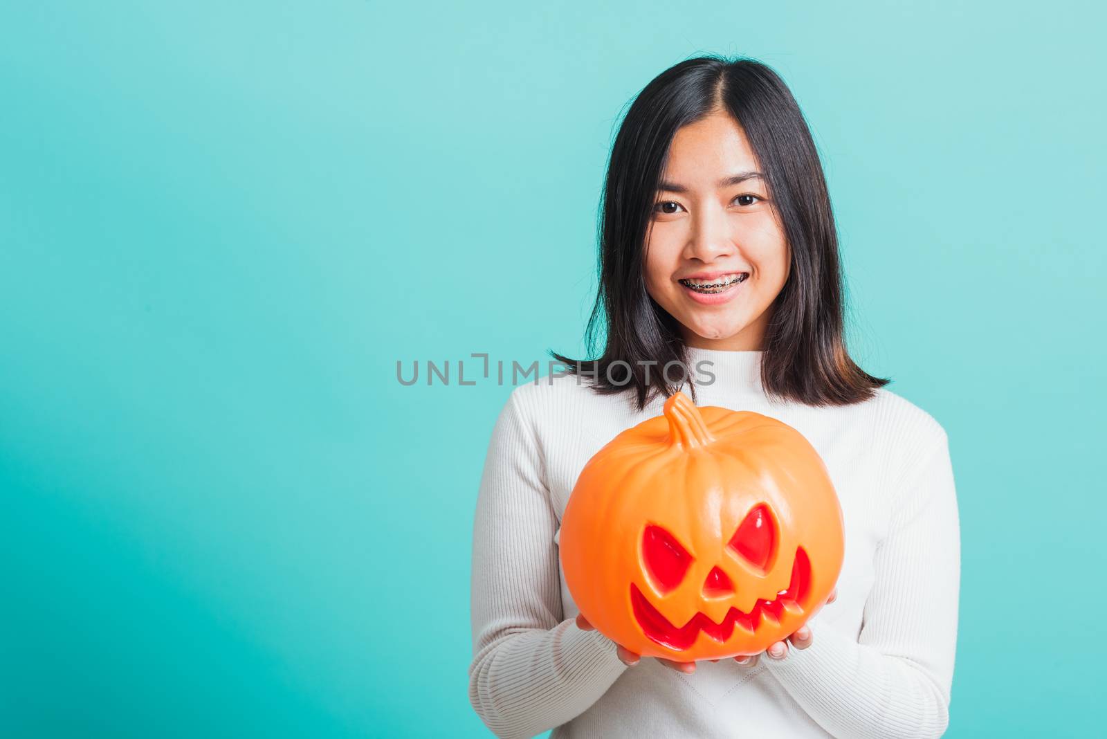 woman holding orange model pumpkins by Sorapop