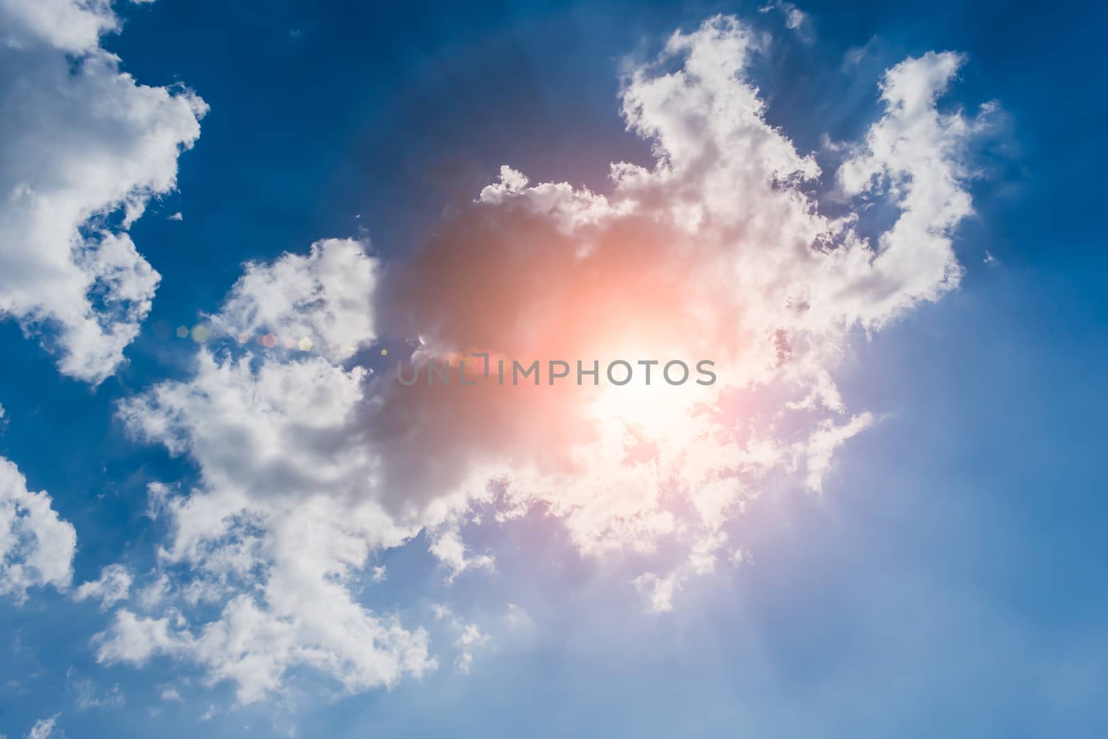 The bright rays of the sun making their way through the clouds ha blue sky