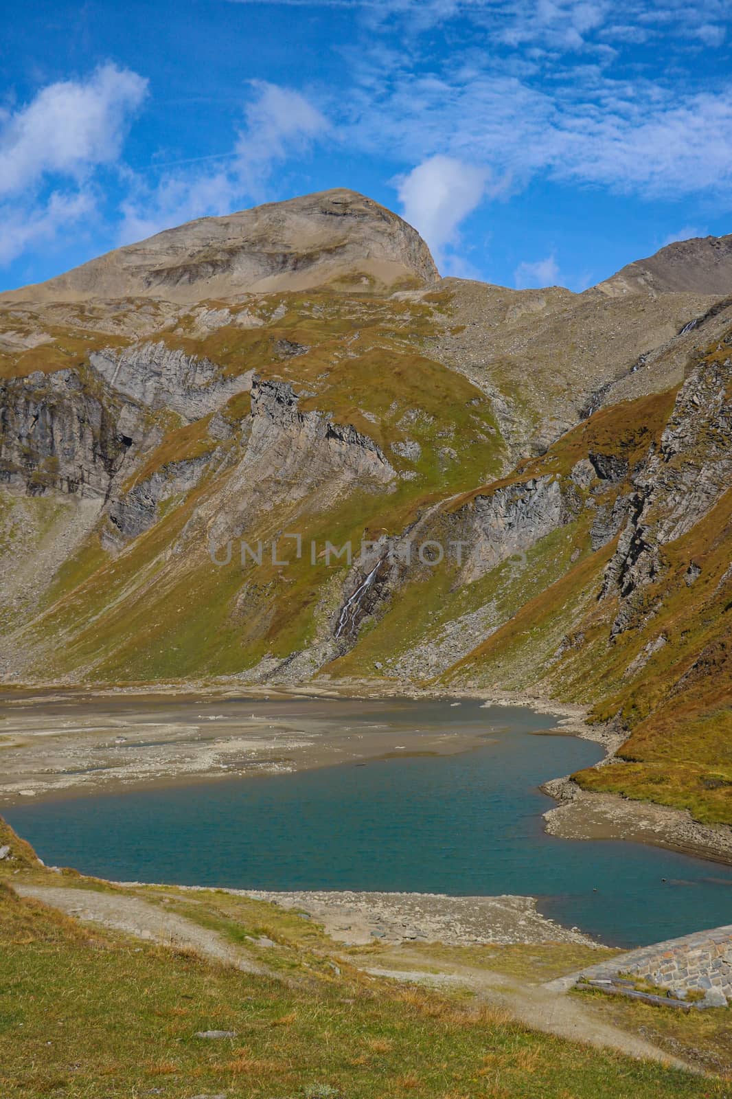 Mountain lake. Tourist route and a green valley between the mountains in Austrian Alps